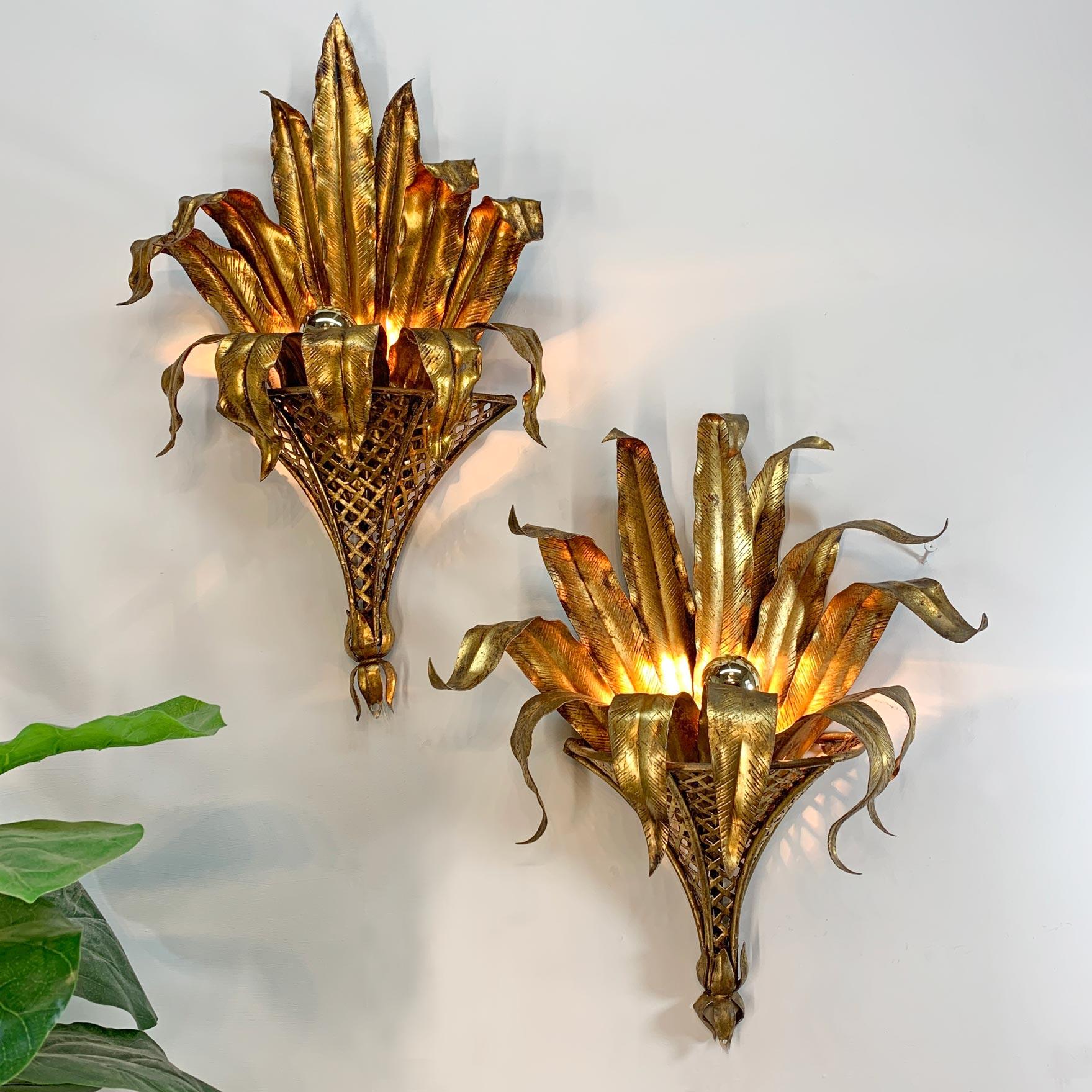 Fabulous pair of 1950’s Italian wall lights, the gilded iron modelled as large, outstretched palm leaves sitting within an upturned coronet. Slight difference in the gilt finish due to the hand-crafted nature of these stunning pieces.

Can be hard