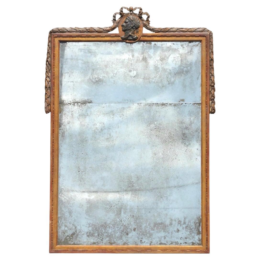Grande coppia di specchi italiani in Wood Wood dorati in stile neoclassico. Gli specchi presentano una doppia lastra a specchio incorniciata da una modanatura a perline finemente intagliata, sormontata da un'intricata cresta scolpita che raffigura