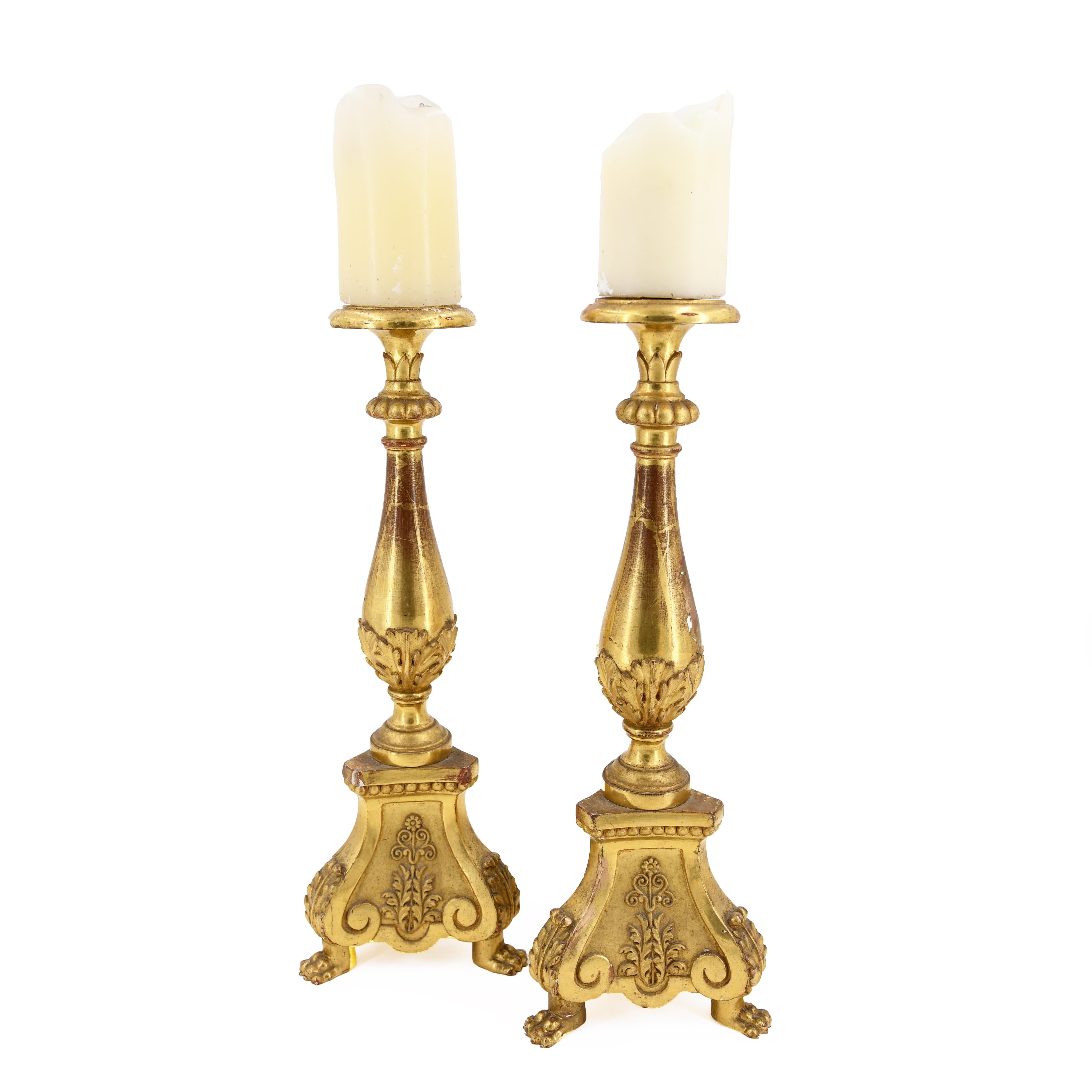 Fourth quarter 19th century, in the neoclassical taste, the baluster-form standards decorated with acanthus leaves and fitted with flaring drip pans and pricket candle holders, raised on tripartite bases decorated with panels of flowers and leaves