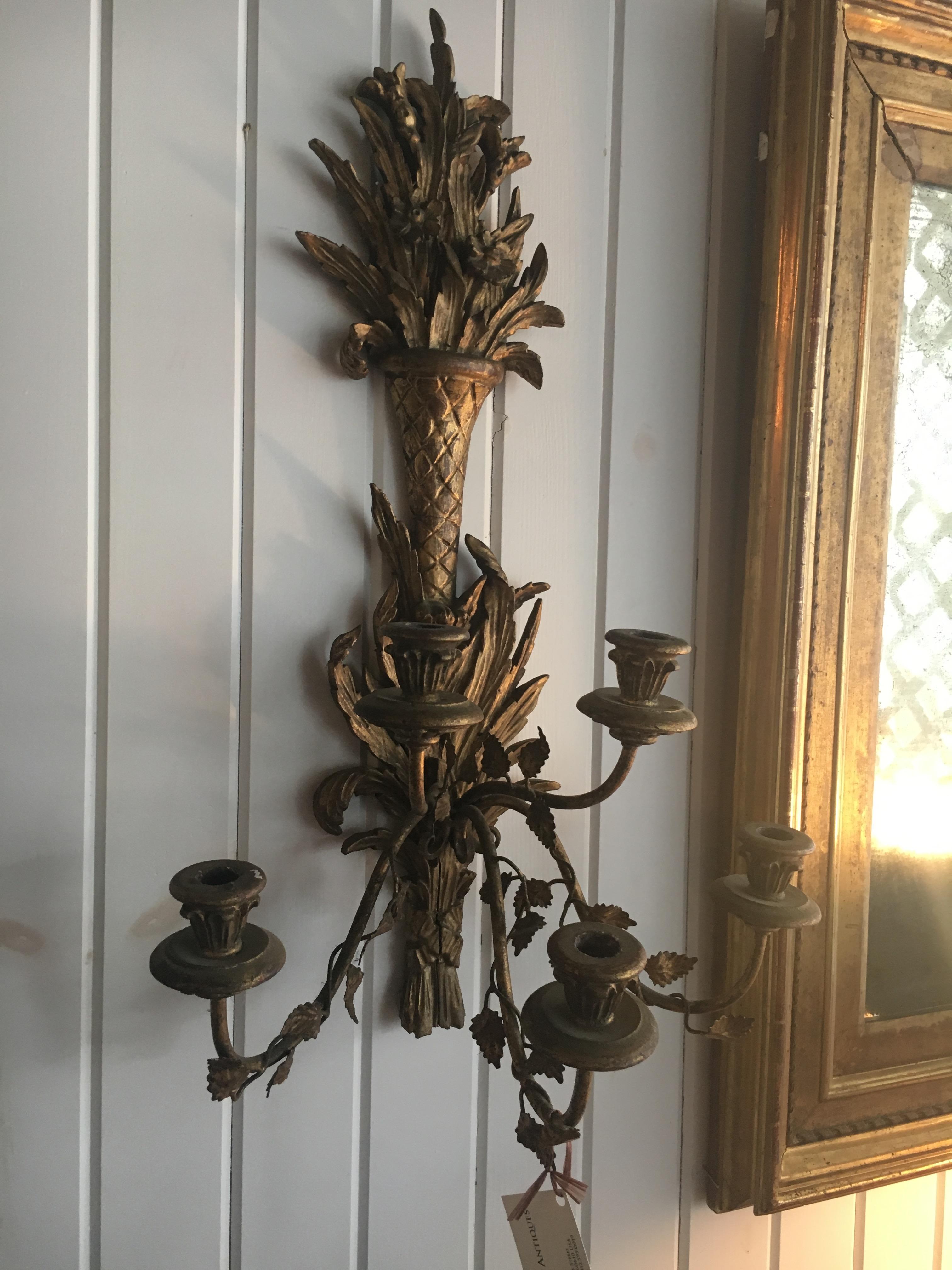 A pair of Italian giltwood carved three-arm sconces. Fine detailed carving with wonderful old patina.