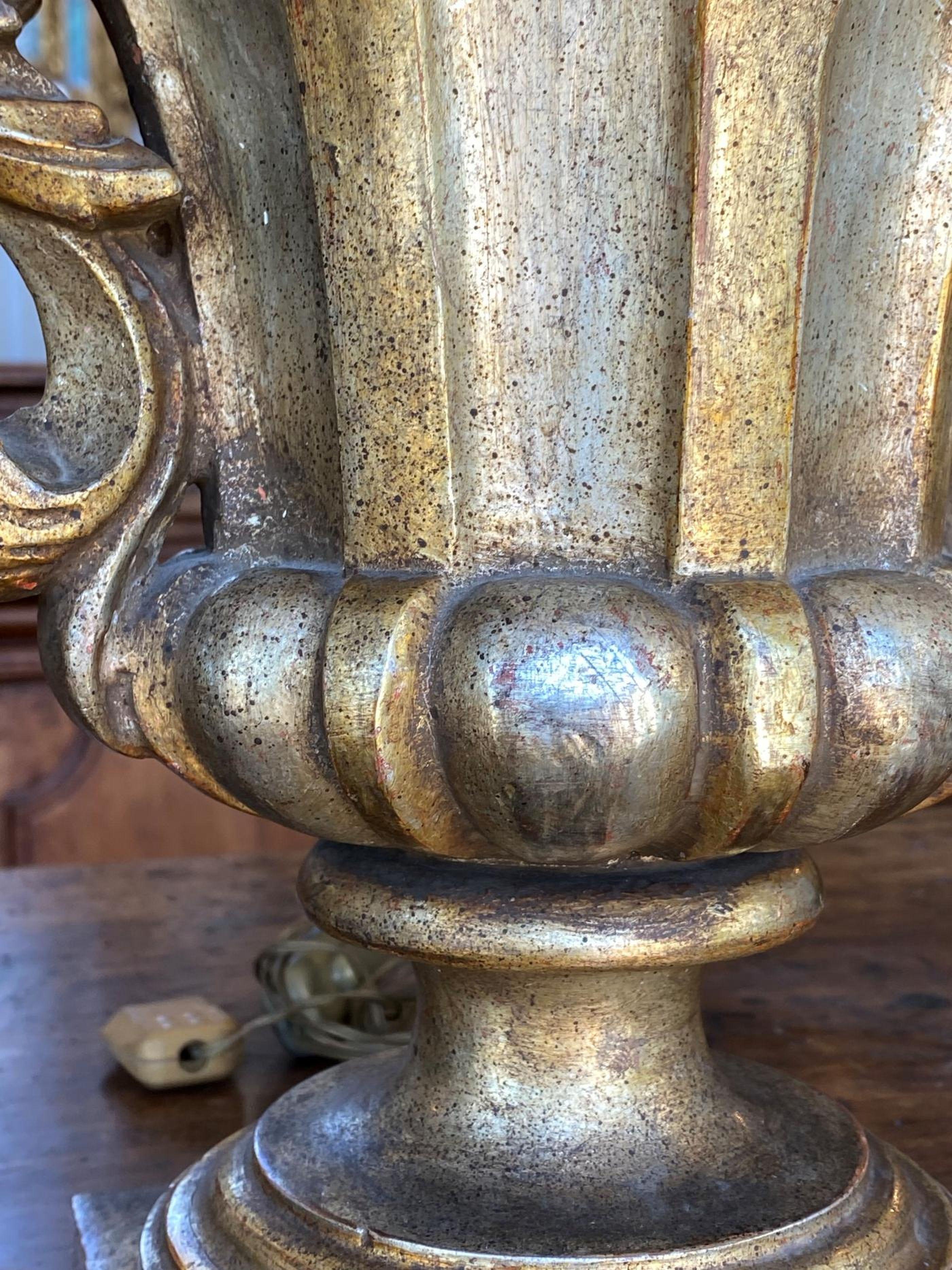 Chaque urne lobée est flanquée de deux poignées en volute sur une base carrée percée et montée comme une lampe de table. 
