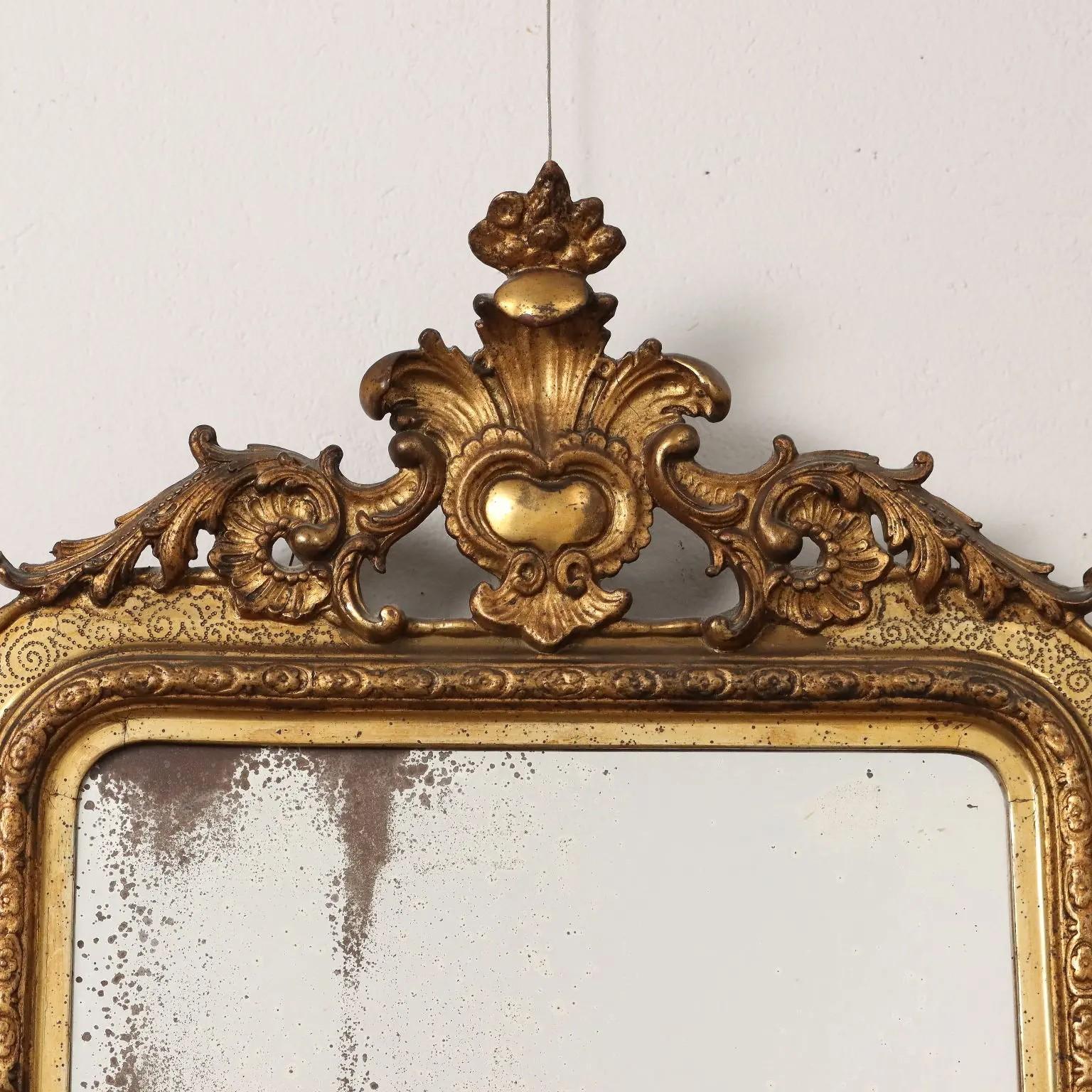 Piatto rettangolare all'interno di una cornice di legno dorato intagliato con angeli fuoriusciti, sormontato da una cresta fogliare traforata. 