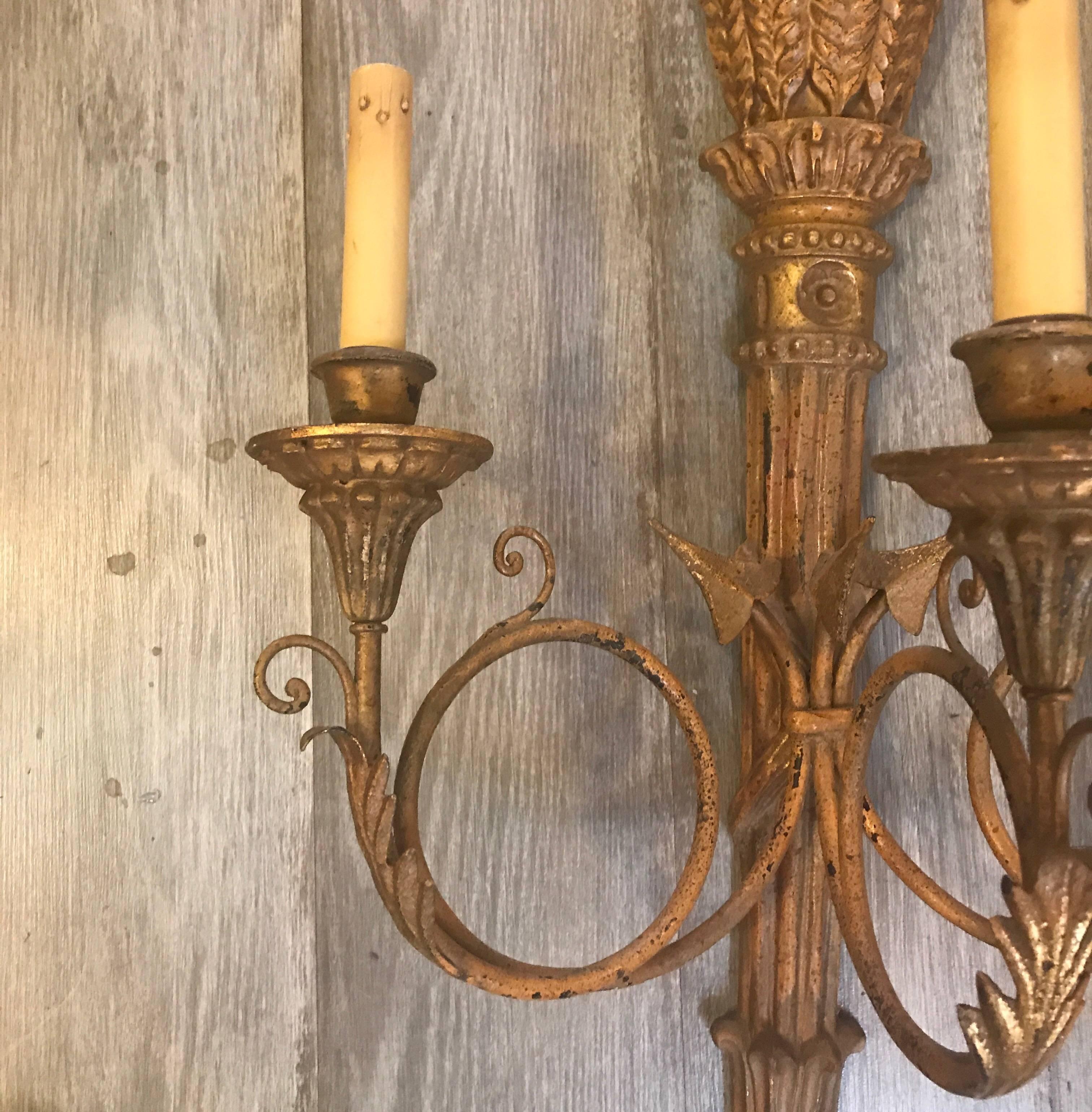 A pair of three-arm Italian giltwood sconces with French Horn style arms. The center column, with wheat top carving and reeded torch. The finish is weathered gilt.