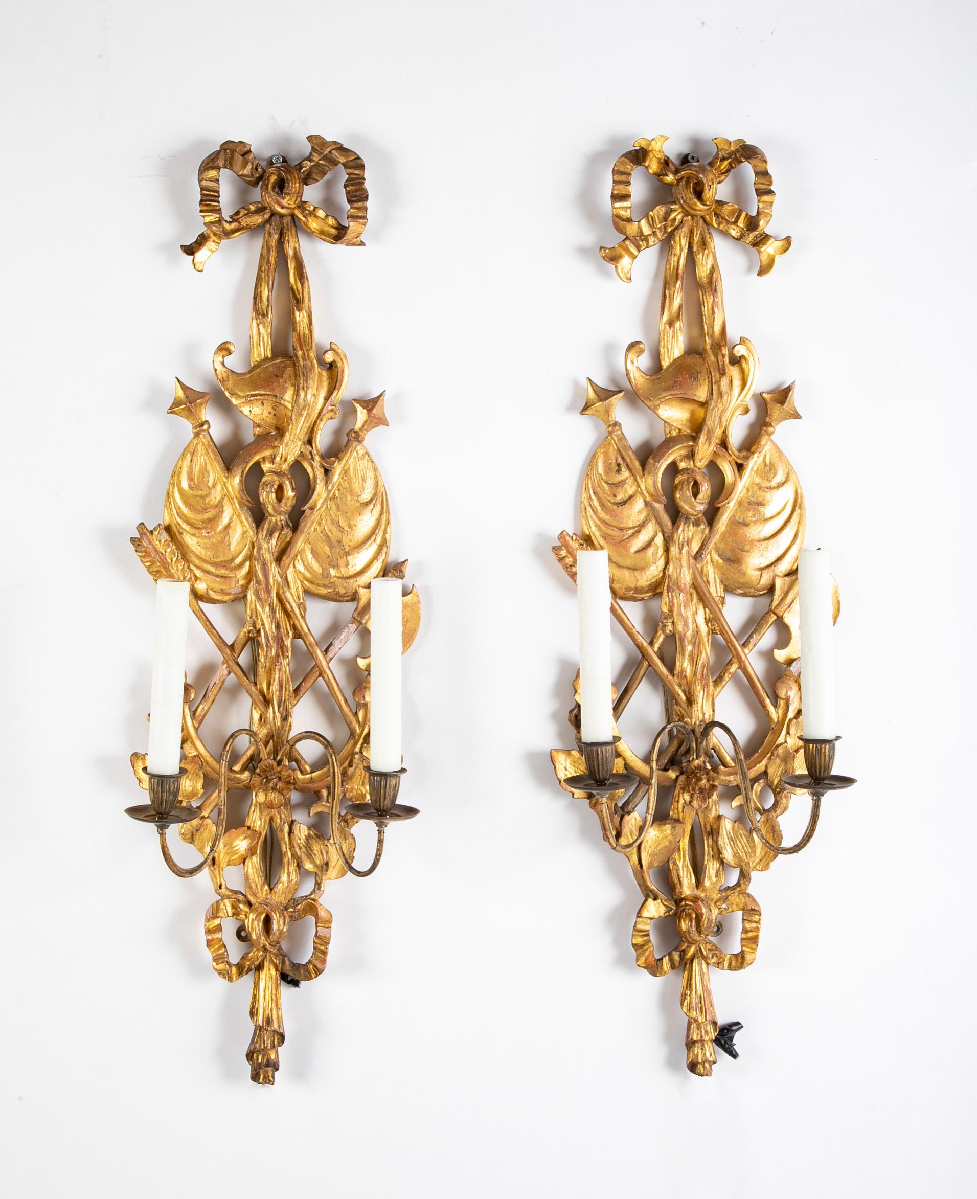 A pair of Italian wall sconces in Neoclassical trophy form of gilt softwood now electrified.  Circa 1860.    