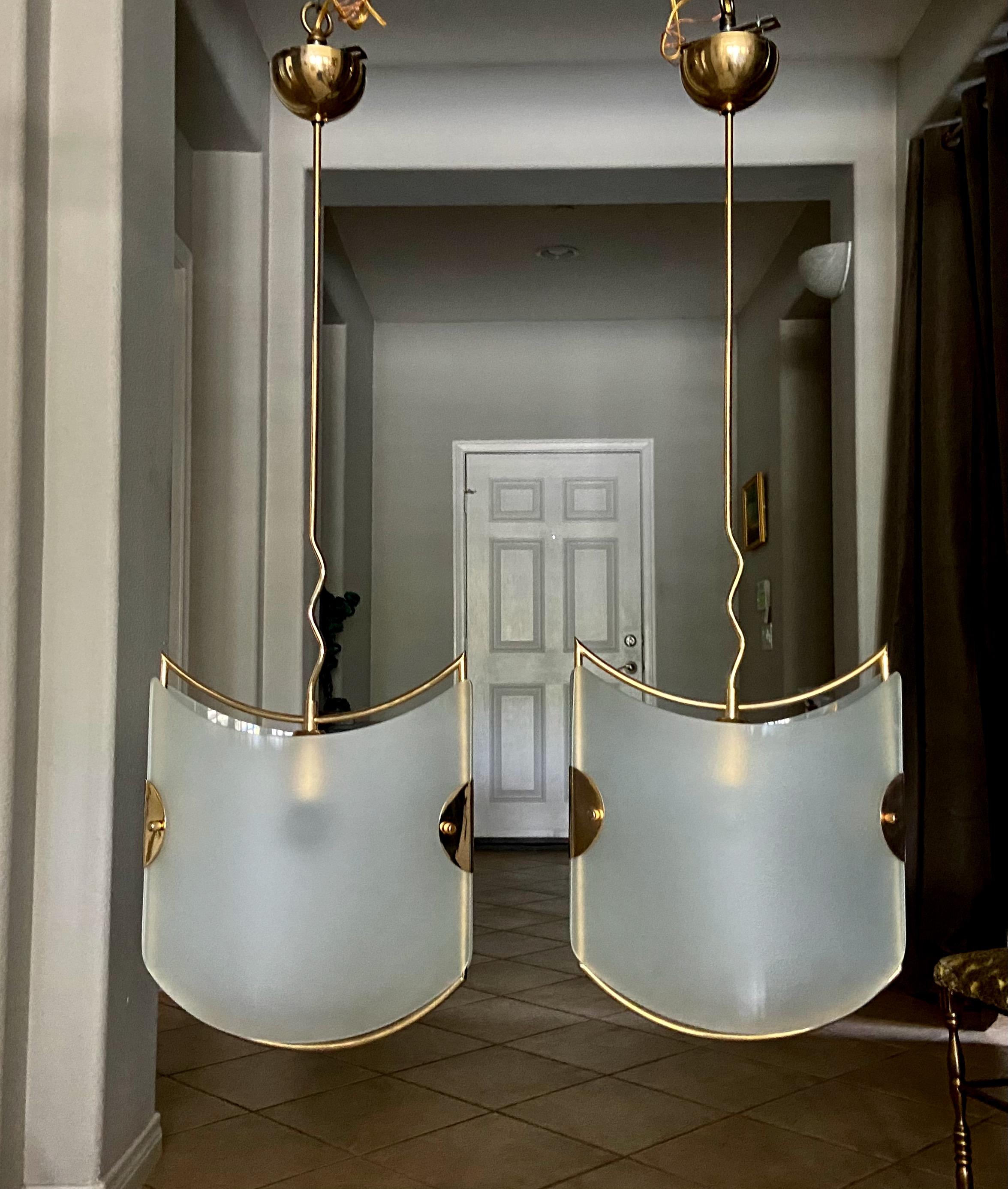 Pair of Italian pendant lights with frosted glass panels and brass finish frames. The modern style is very much in the manner of Gio Ponti for Fontana Arte. In addition to using in an entry or hall, this pair would look perfect over a kitchen or bar