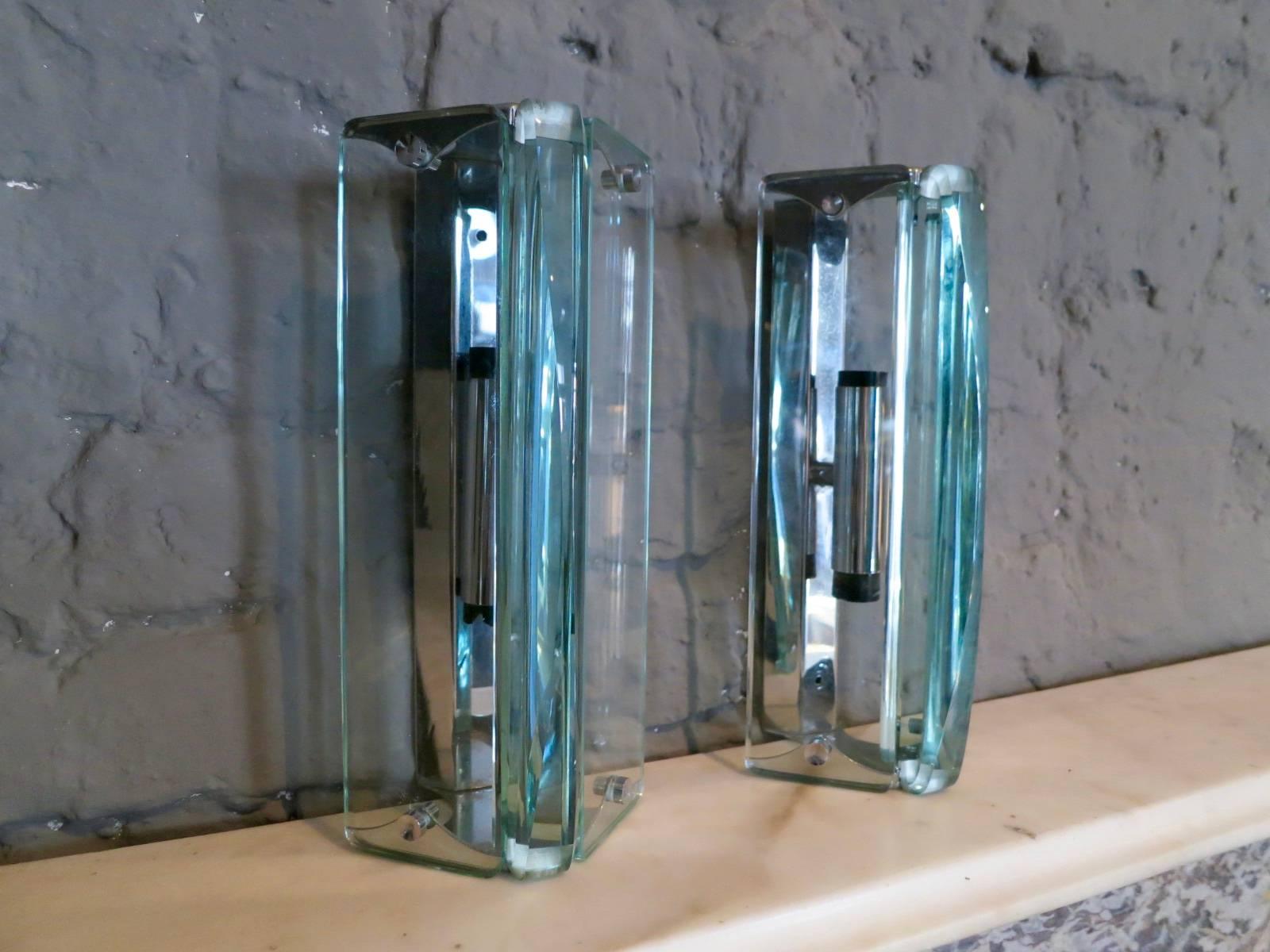 A smart pair of sconces in the manner of Fontana Arte, with chrome fitting and thick cut curved glass diffusers.