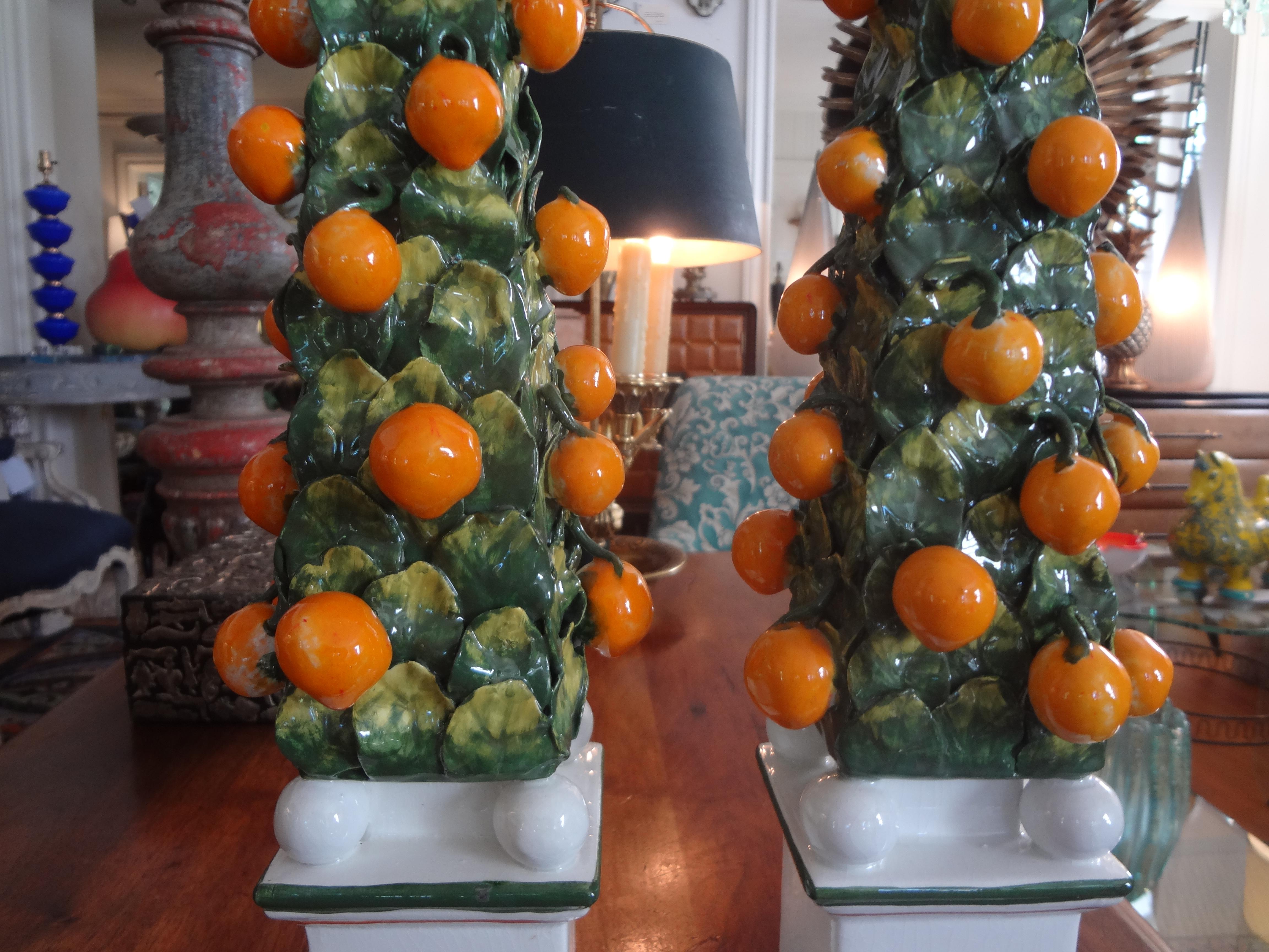Great pair of vintage Italian glazed ceramic topiary obelisks. This unusual pair of obelisks is adorned with leaves and oranges. This lovely pair of garniture dates to the 1970s.