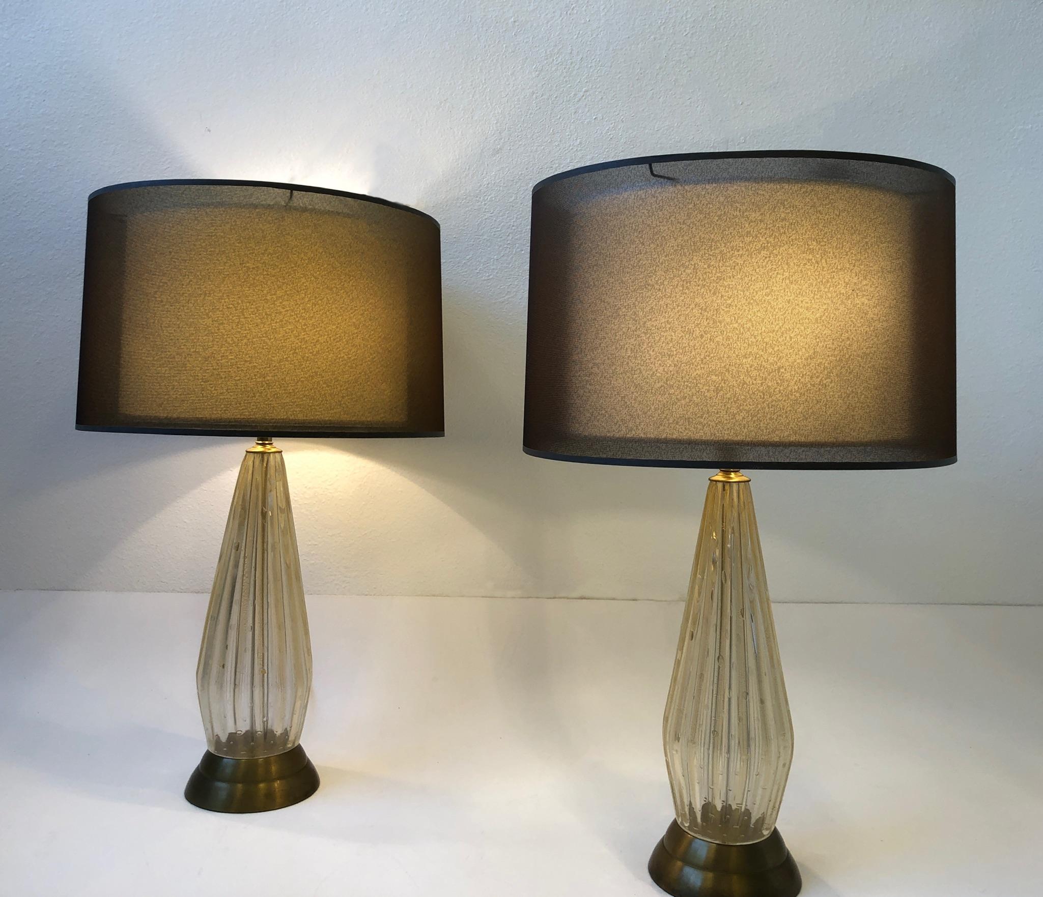 Glamours pair of 1960s Italian gold dusted murano glass with brass hardware table lamps by Marbro Lamp Company.
Newly rewired with new brass hardware and brown cloth wire. 
We purchased the lamps with the double drum shades. 
Measurements: 21”