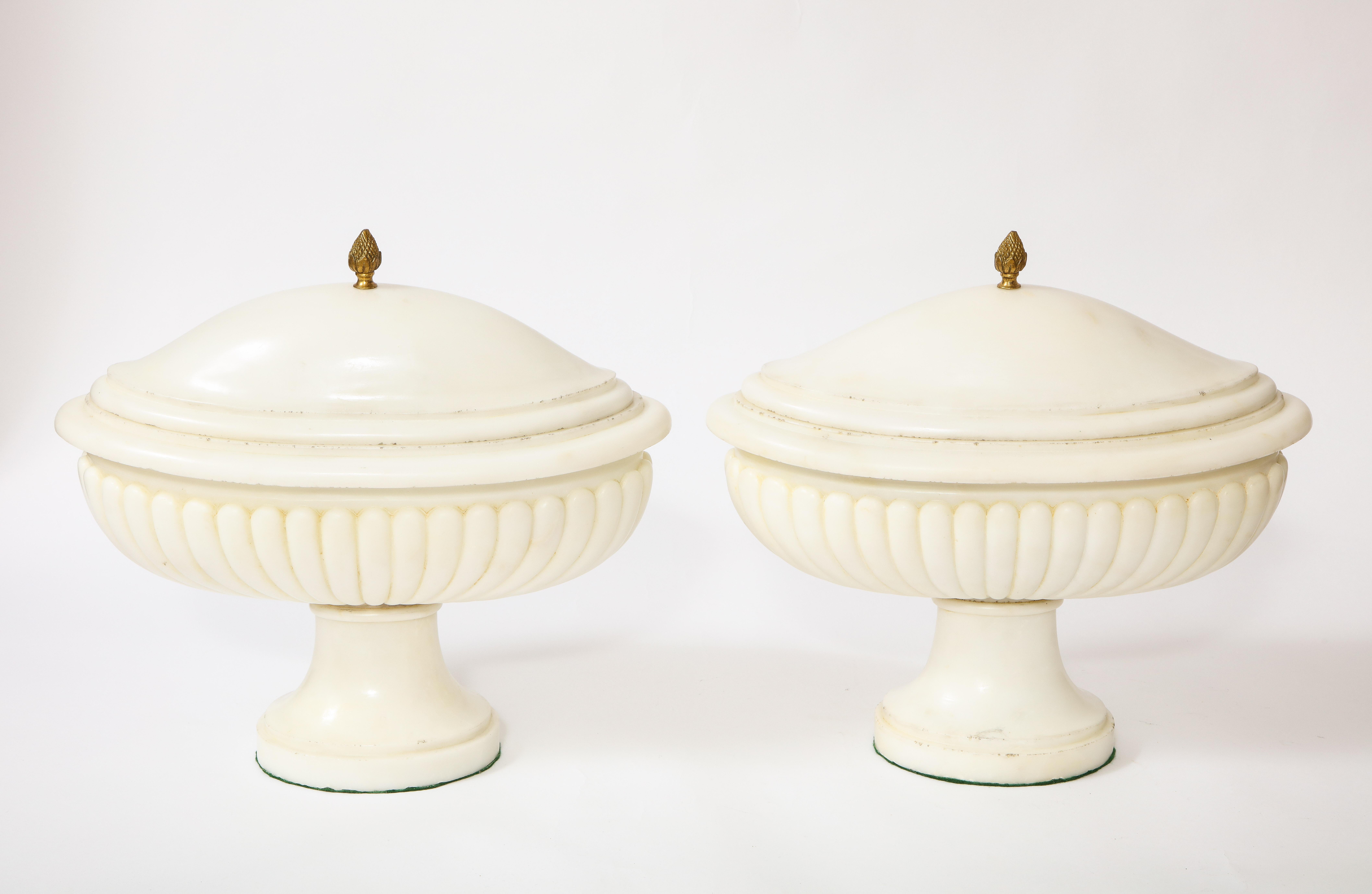 A gorgeous and finely hand-carved pair of grand-tour period neoclassical style Carrara marble covered bowls/centerpieces. Each piece is of oval form with hand-carved scalloped bodies. The tops are also hand-carved with the finest Italian Carrara