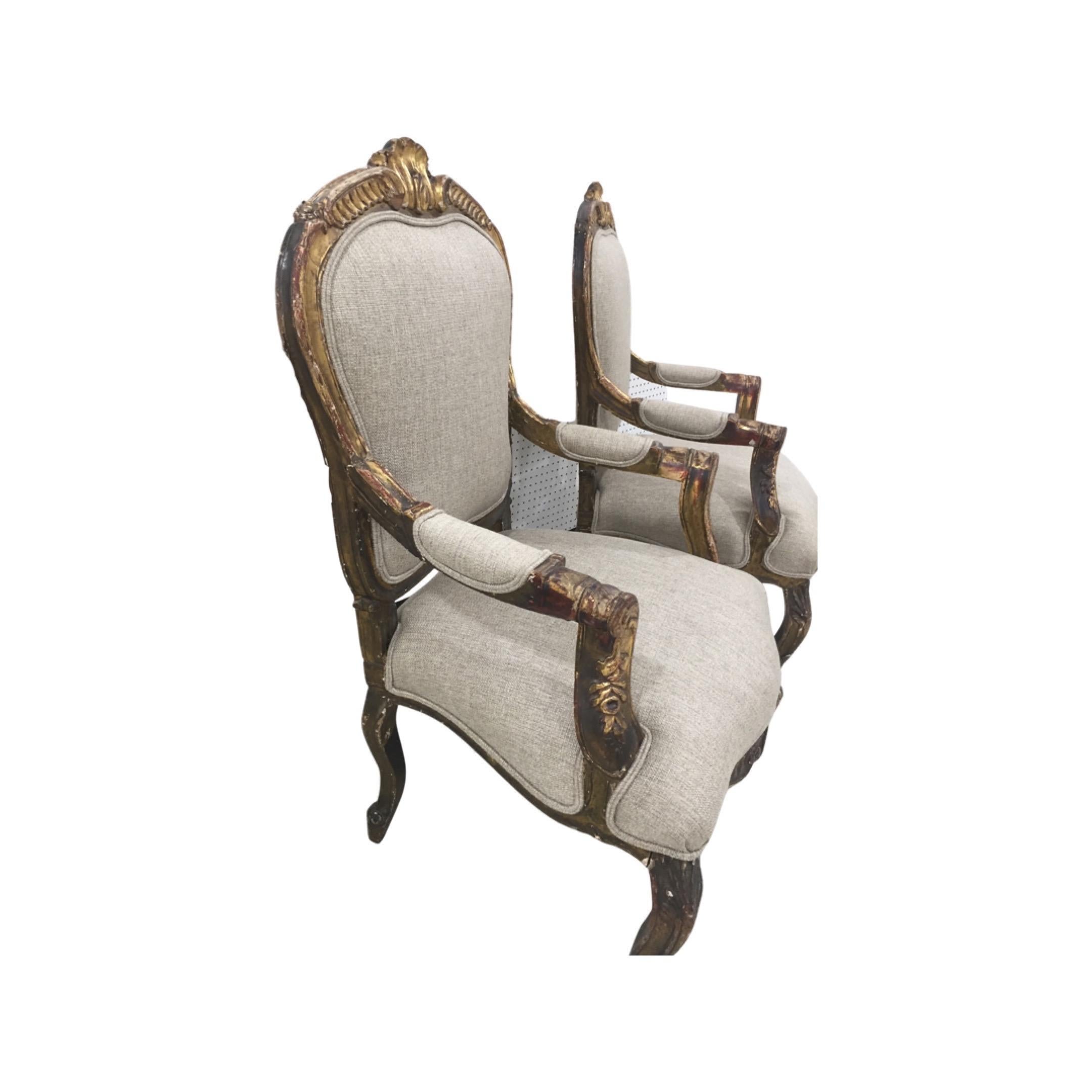 Pair of 19th C Italian painted and giltwood fauteuil armchairs in the Louis XV style. Scrolled arms and legs with applied floral decoration. Back with gilt stylized shell decoration. Chairs have gentle worn patina that indicate the age of the