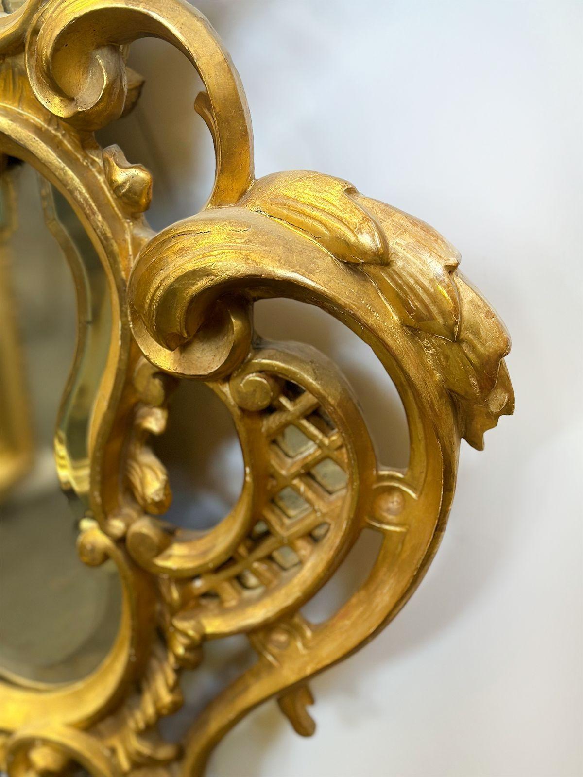 Paire de magnifiques miroirs en bois doré sculptés à la main, fabriqués en Italie vers les années 1900. Les cadres de ces miroirs sont resplendissants de bois doré sculpté à la main, magnifiquement ornés de motifs feuillagés complexes. Ces motifs,