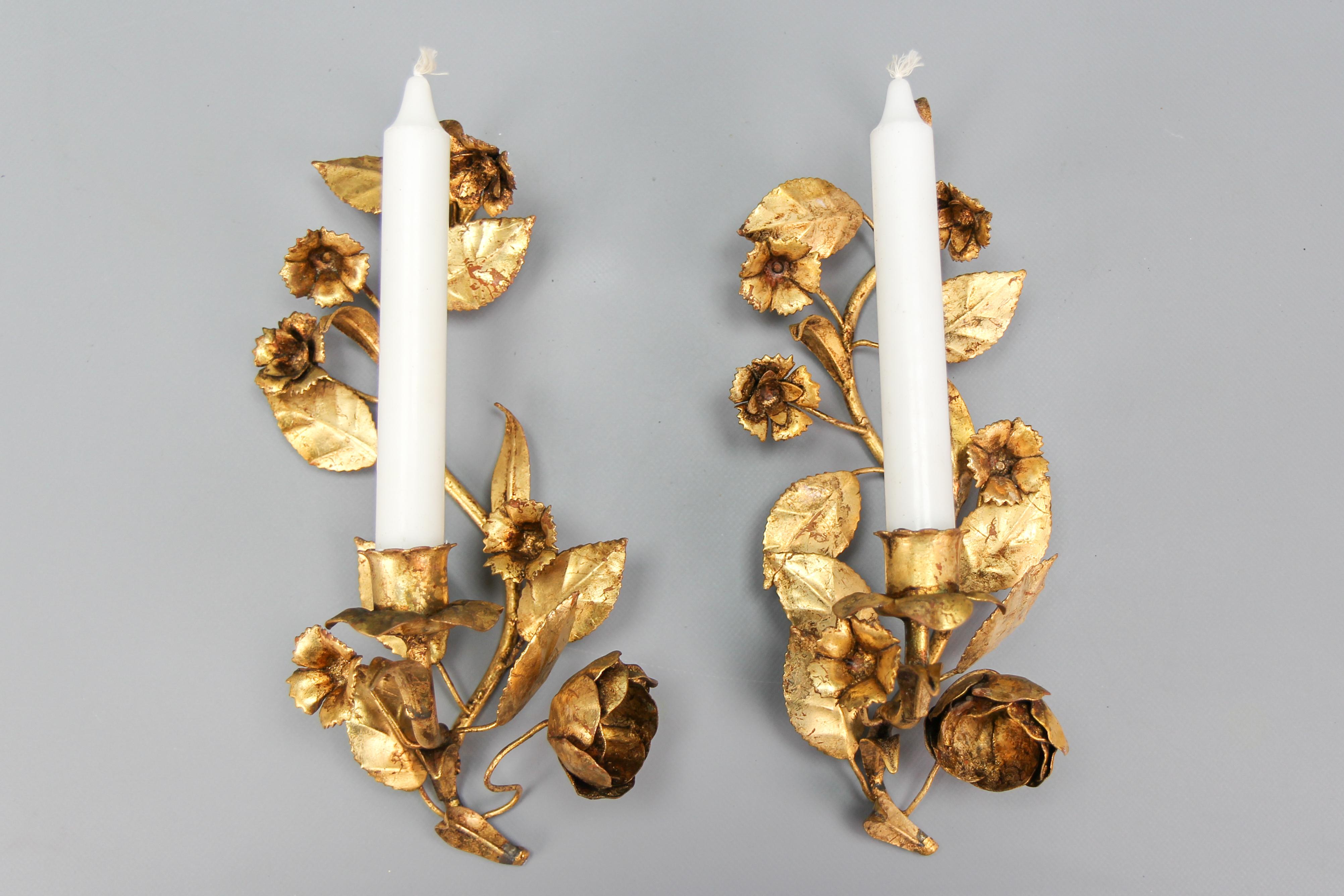 Pair of Italian Hollywood Regency gilt metal floral candle wall sconces.
This beautiful pair of gilt metal wall lights features leaf, flower, and roses motifs, each wall sconce with one candle arm.
Italy, circa the 1960s.
Dimensions: height: 30