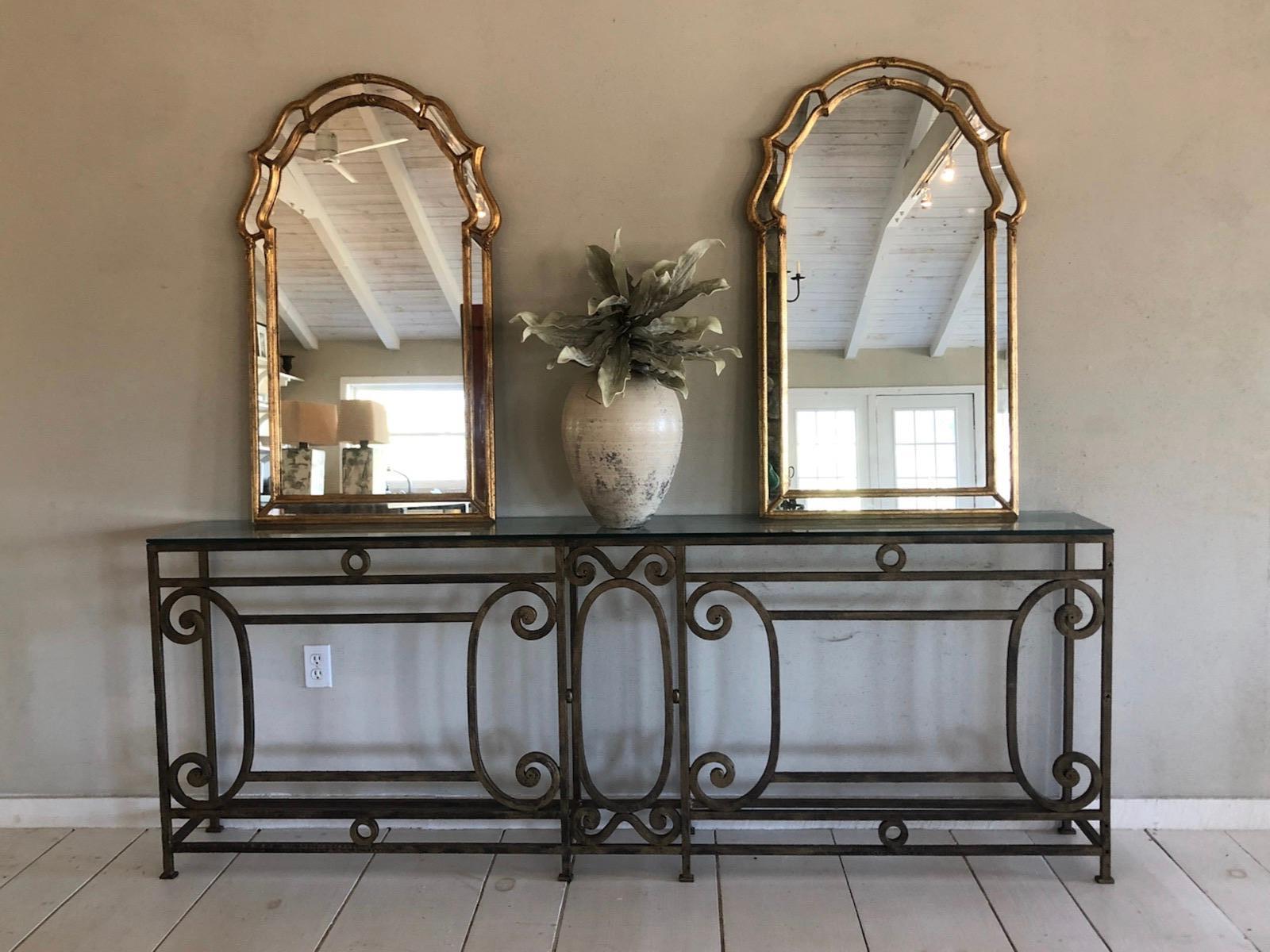 Pair of stylish modern 1970's Italian mirrors with a gilt finish. The mirrors have an arched top and geometric sides, giving this mirror a transitional appeal. The simple elegance of these mirrors lends them to work in classic, period or modern