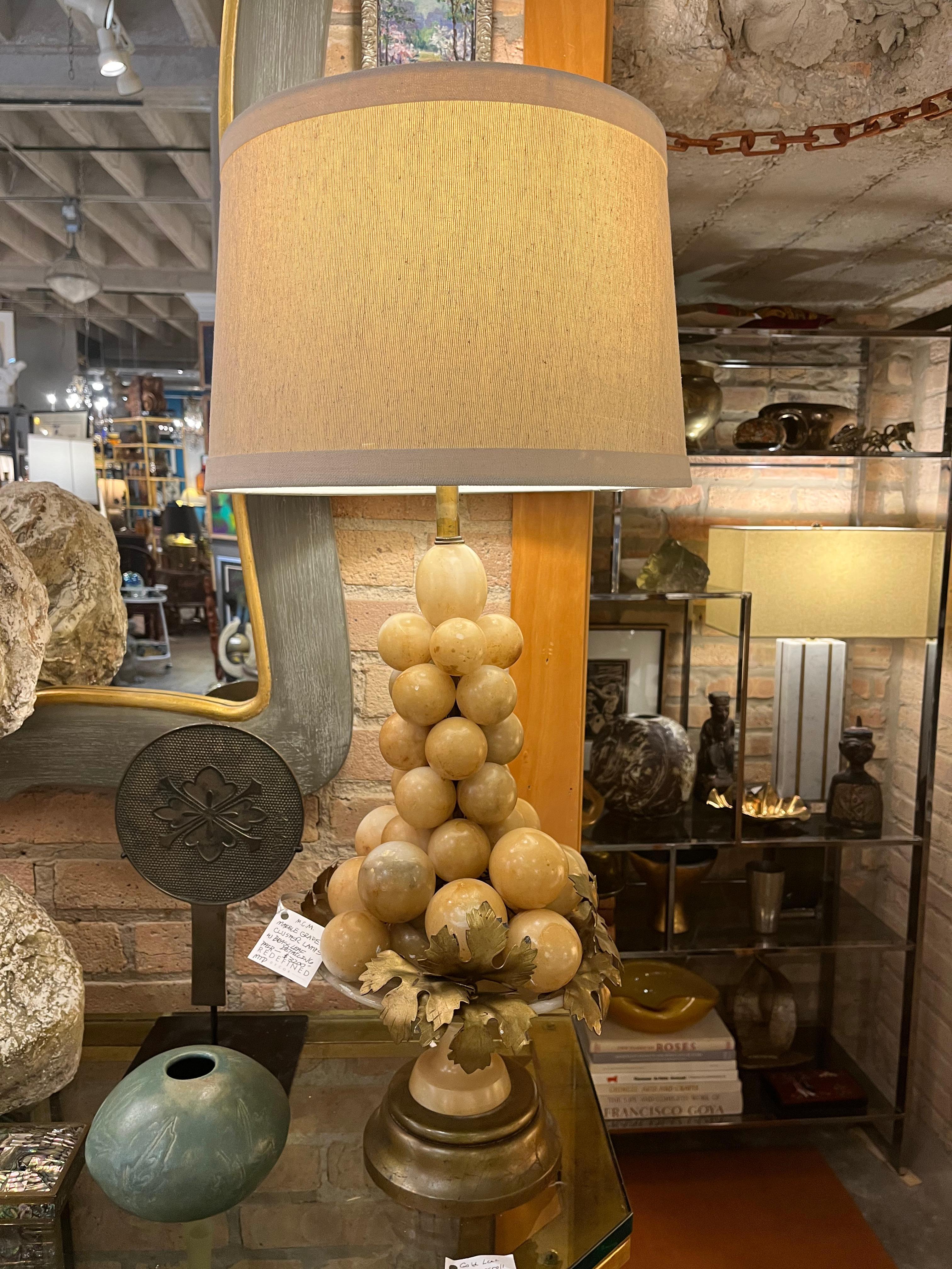 Pair of Italian Hollywood Regency marble grape cluster table lamps having gold leaf decoration. All mounted in alabaster compote bases. The shades are not included with the lamps.