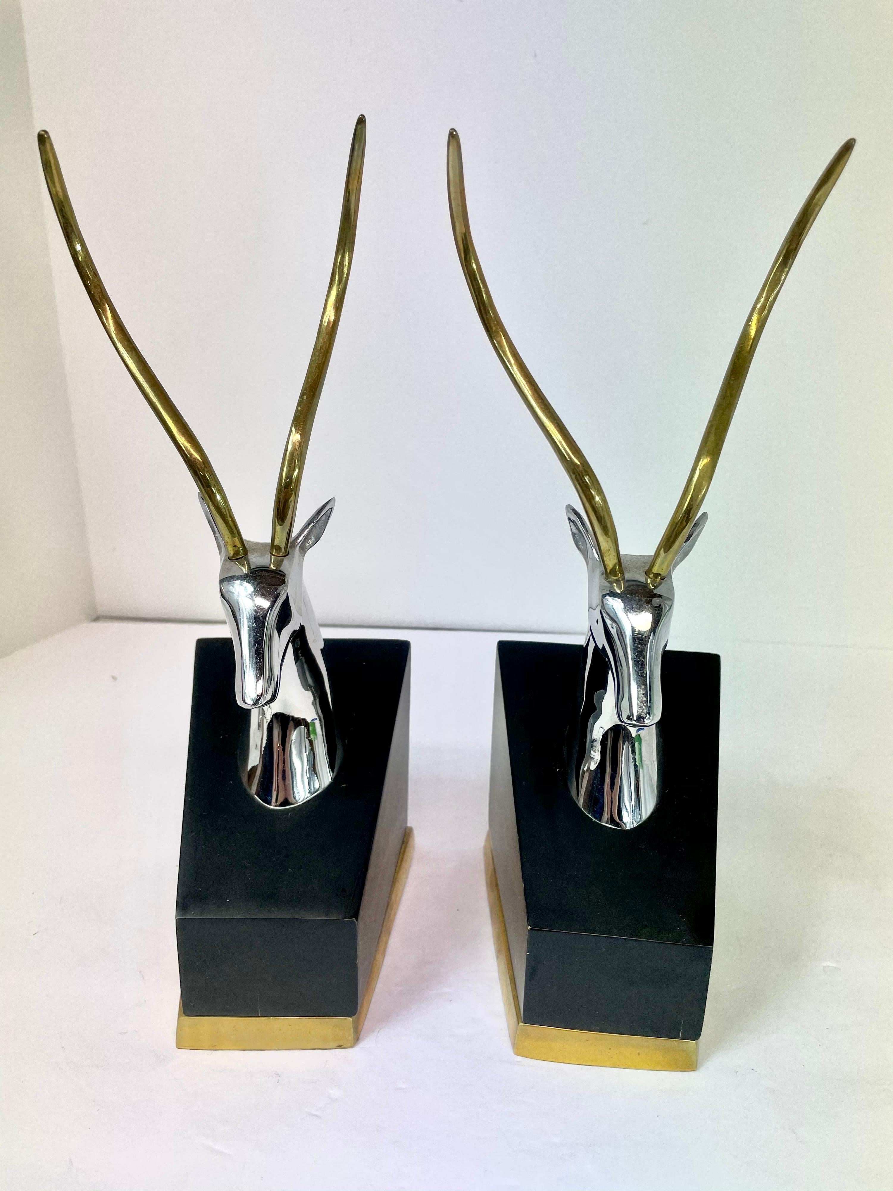 Pair of impala bookends in polished brass and chrome on wood bases banded in brass. Nice large size. Looks great on the bookshelf! Brass and chrome are both in very good condition. Measurement is for each book end.