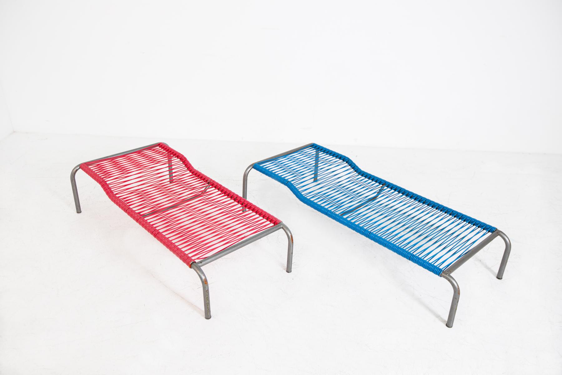 Pair of vintage 1950's Italian deck chairs. The pair of deck chairs is made with a tubular iron frame. The peculiarity of the deckchairs is their seat totally made with plastic interlaced filaments of two colors, red and blue. The deckchairs can