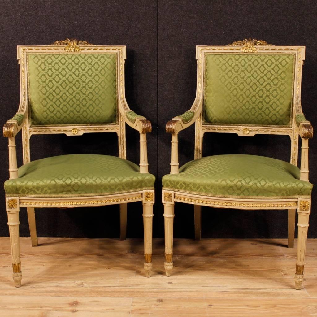 Pair of Italian armchairs from 20th century. Furniture in richly carved, gilded and lacquered wood in Louis XVI style. Armchairs covered in green fabric in good condition (they have a small tear). Comfortable seats with padding in good condition.