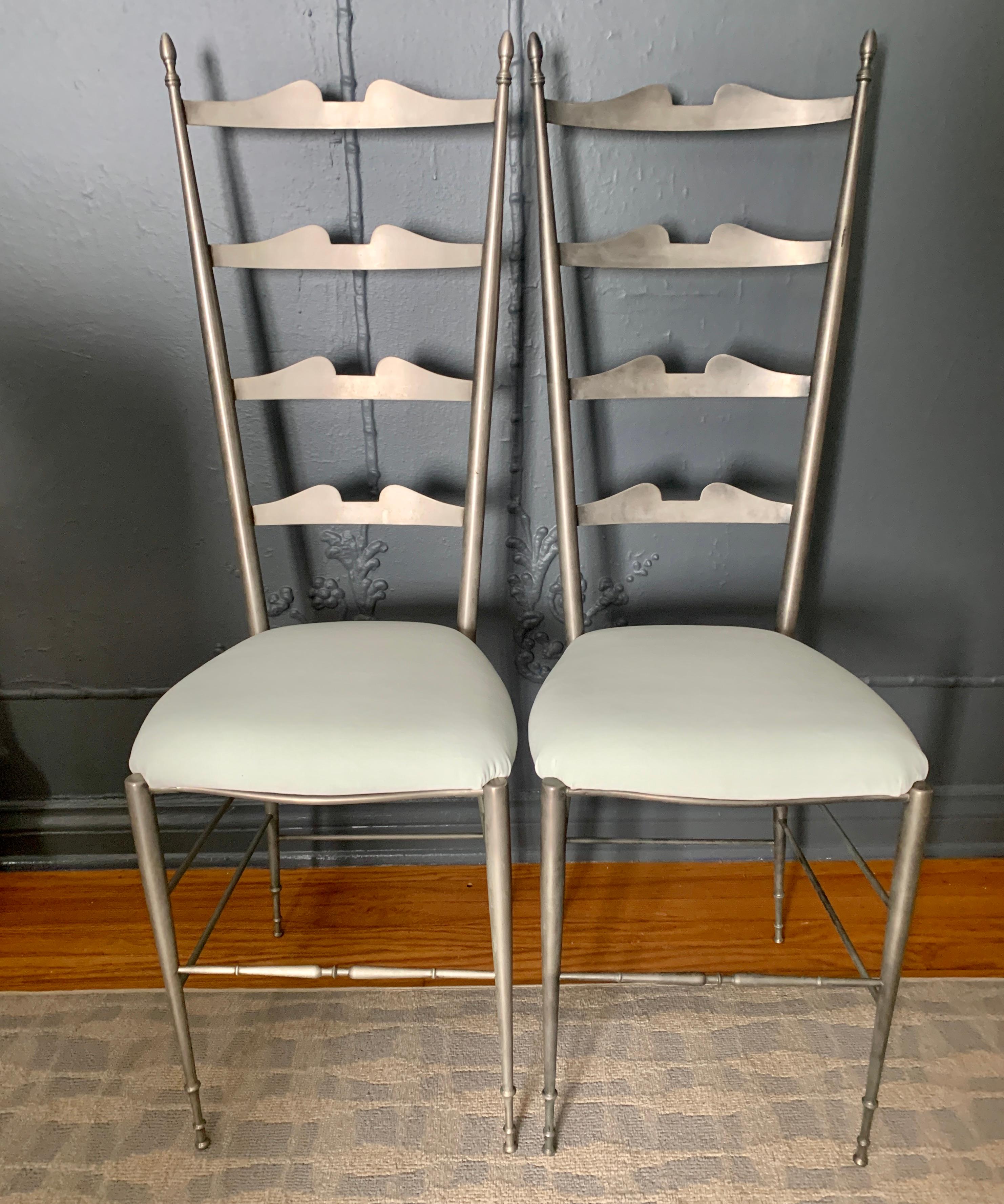Pair of Chiavari Italian chairs, in a rarely seen pewter metallic finish. The pair feature a lovely and graceful ladder back and are newly upholstered in Belgian Velvet. A stunning pair to flank a doorway, a wonderful decorative touch.

The pair