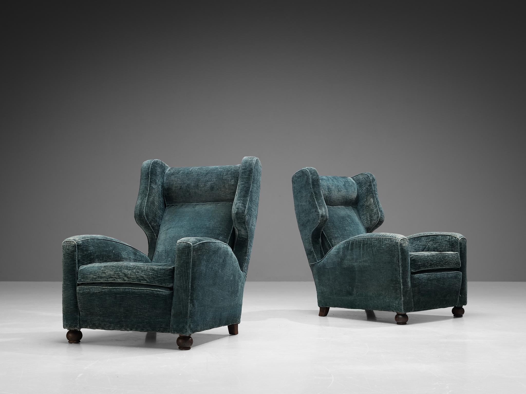 Pair of lounge chairs, velvet, wood, Italy, late 1940s.

These Italian Postwar wingback chairs have an unusually high back and gracious ears. The armrests feature pronounced curves that give the utmost comfort for the sitter. The color of the