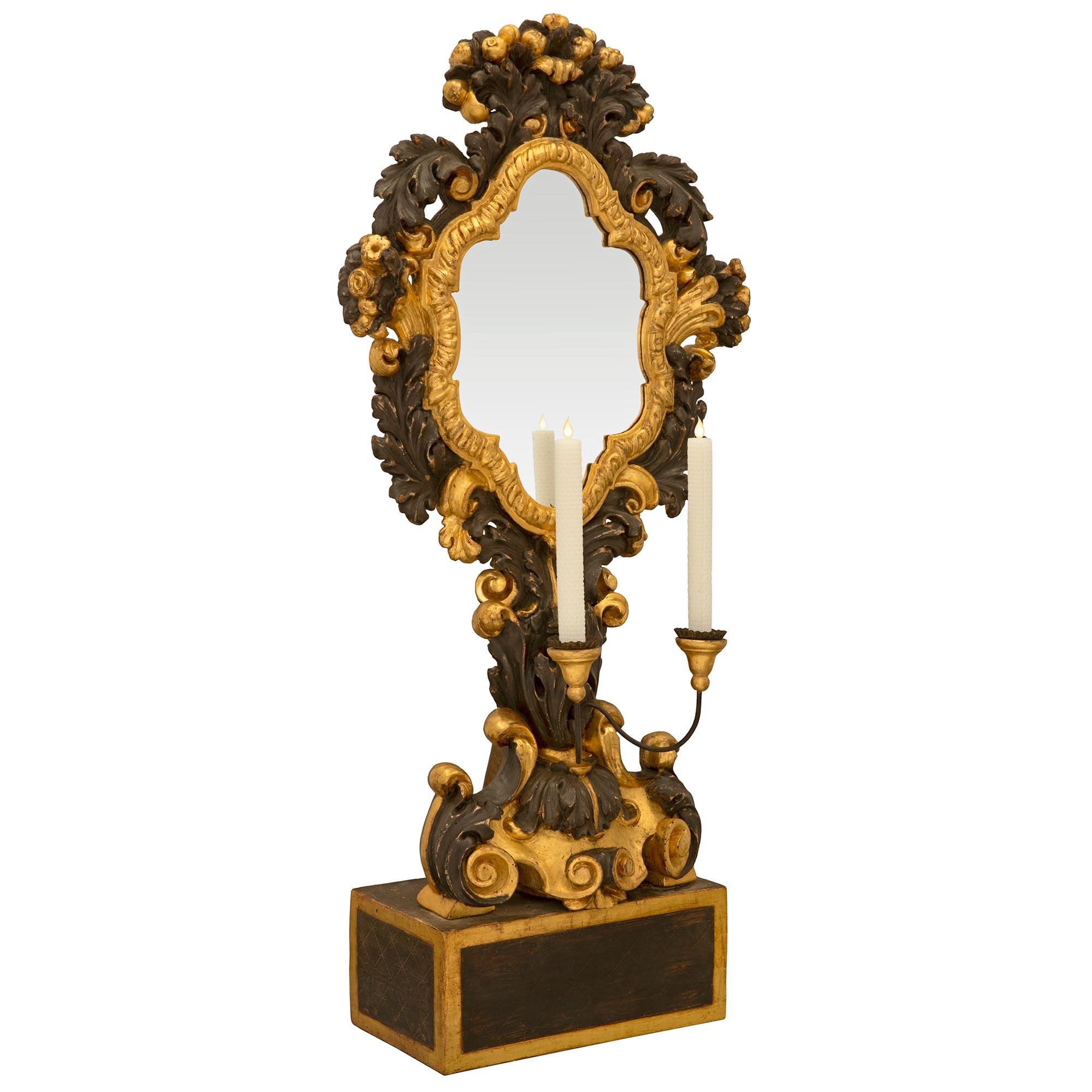 Una coppia straordinaria ed estremamente unica di candelabri a specchio in legno dorato e policromi della fine del XVII secolo. Ogni candelabro è sollevato da una base rettangolare con raffinati bordi in legno dorato al di sotto dell'eccezionale