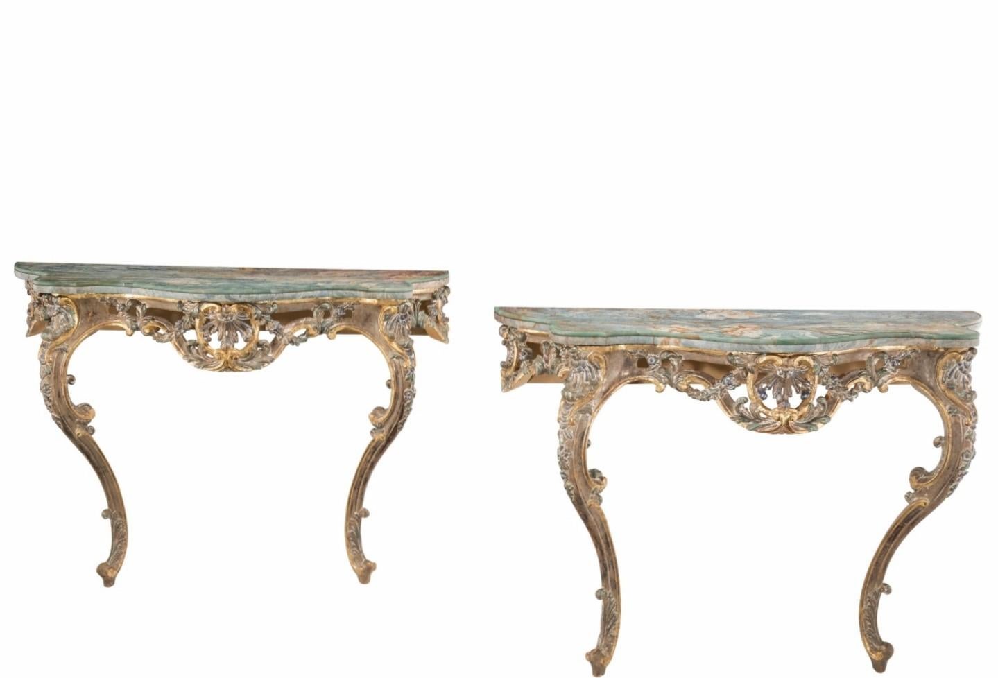 A pair of most impressive Italian hand carved polychrome painted parcel gilt wooden console tables with stunning original serpentine shaped polished Italian onyx dramatically veined marble tops.

Exquisitely hand-crafted in the early 20th century,