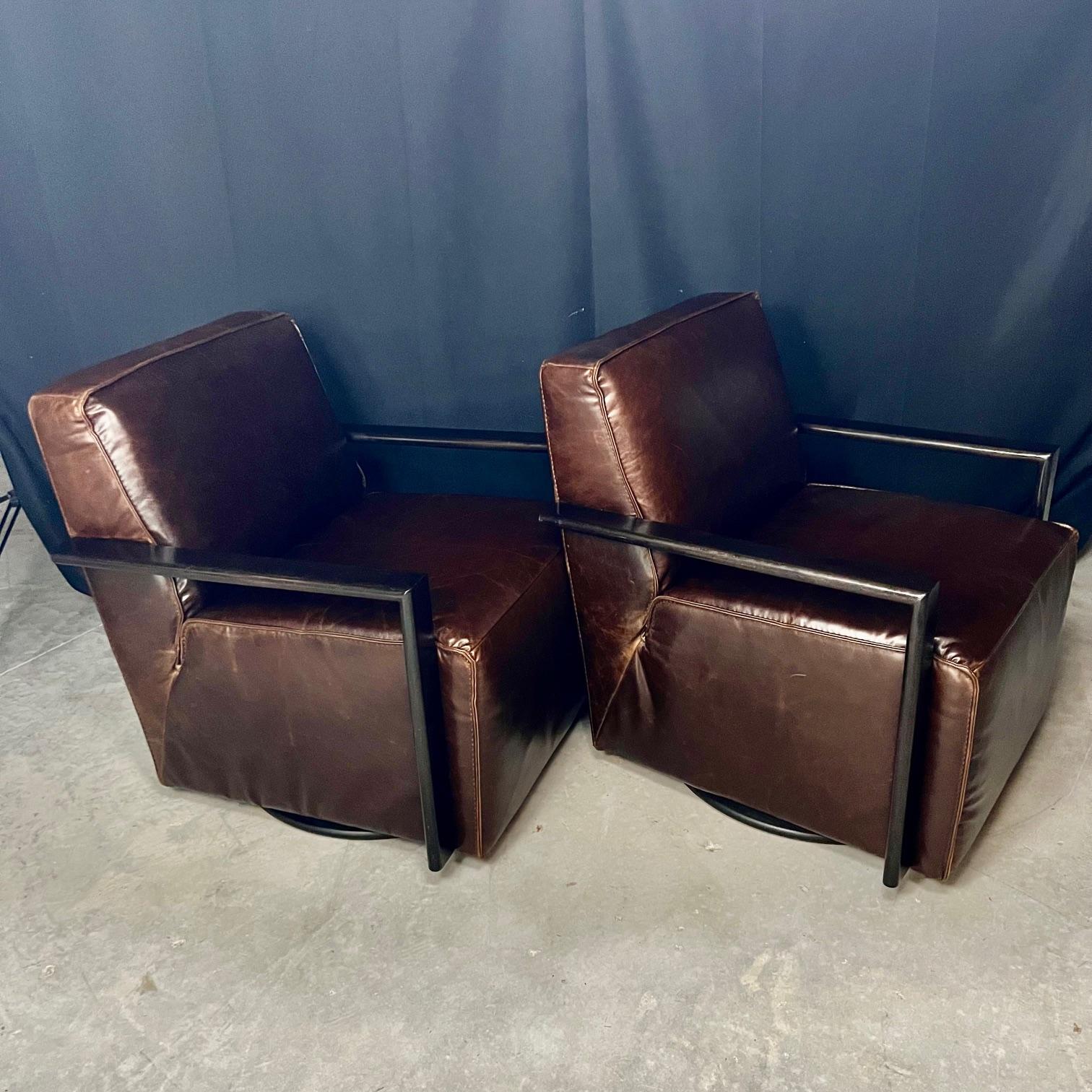 Very stylish Italian pair of swivel leather club chairs having cube form with great comfort and style reminiscent Roche Bobois furniture.   Elegant square forms in chocolate brown leather with hidden black  swivel bases. Wonderful in any room of the