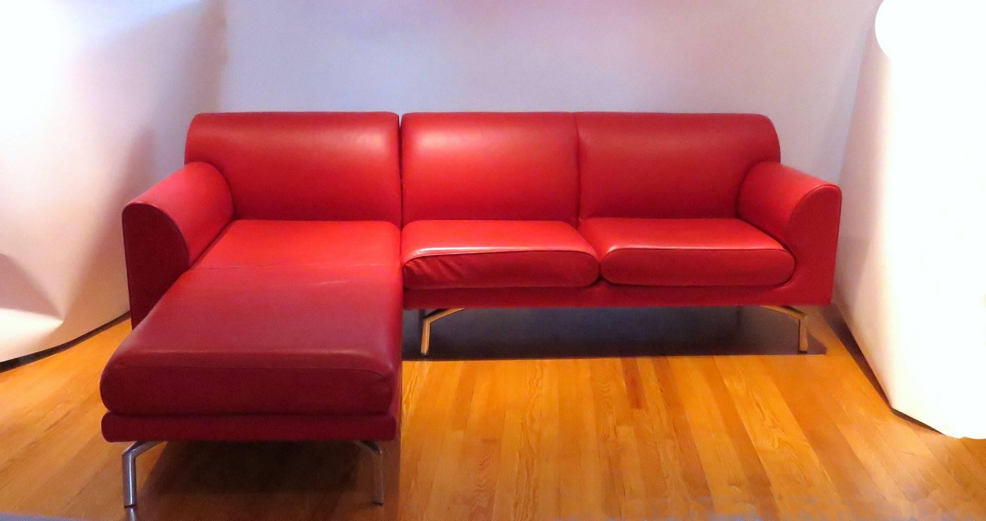 Pair of vibrant red leather sofas by Poltrona Frau from the EOS series, made in Italy, circa early to mid-2000s. The sofas are mirror images of one another. The chaises can be unhooked from the two-seat element of the sofa, and reconfigured to make