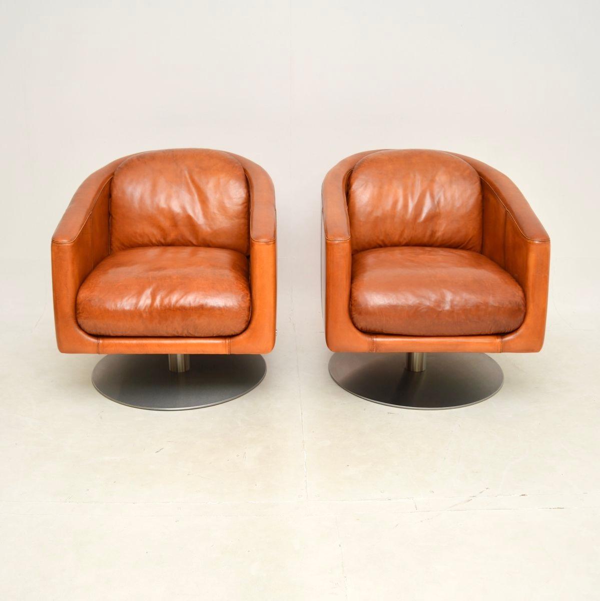 A stylish and extremely comfortable pair of Italian leather swivel armchairs by Natuzzi, dating from the early twenty first century.

They are of absolutely amazing quality, extremely well built and heavy, sitting on brushed steel bases. They are