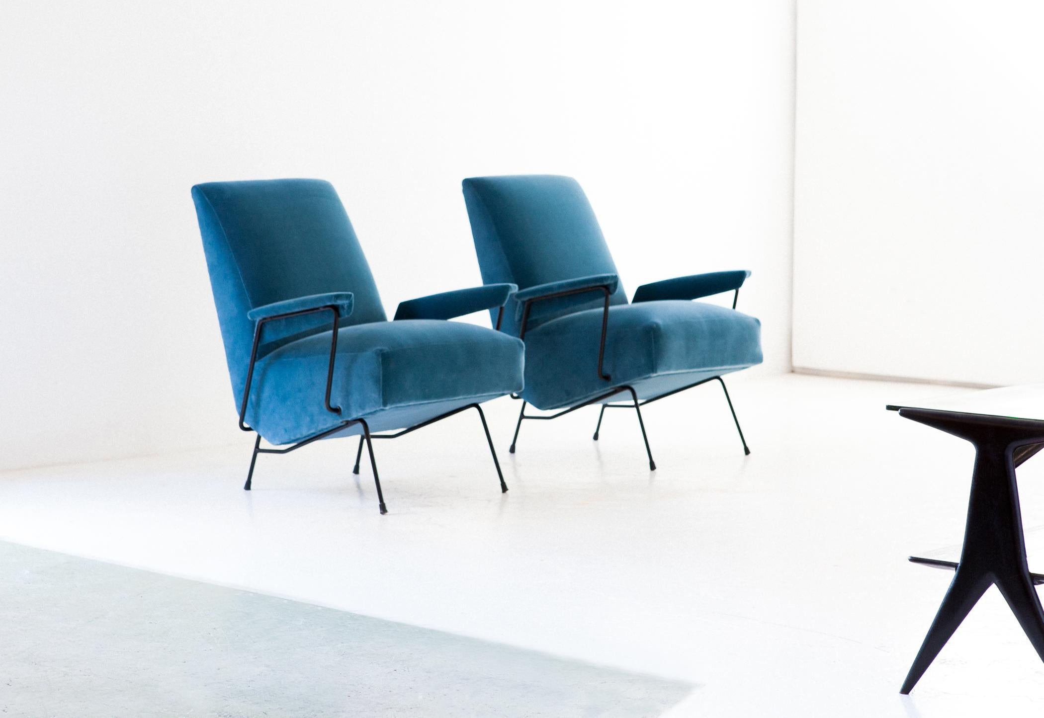 Set of two Mid-Century Modern armchairs, designed and produced in Italy in the 1950s.

These high back lounge chairs has been reupholstered with new light blue velvet , also the padding is new.
These easy chairs has a iron black enameled