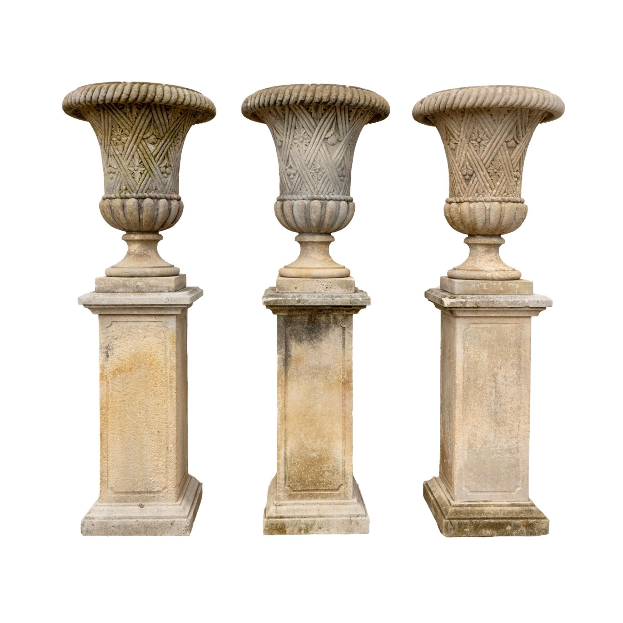 Enhance your garden with a touch of Italian craftsmanship. These elegant limestone planters, sold as a pair, feature intricate carvings of line work and floral motifs. Made in Italy in the 1890s, each planter comes with its own base and can be moved