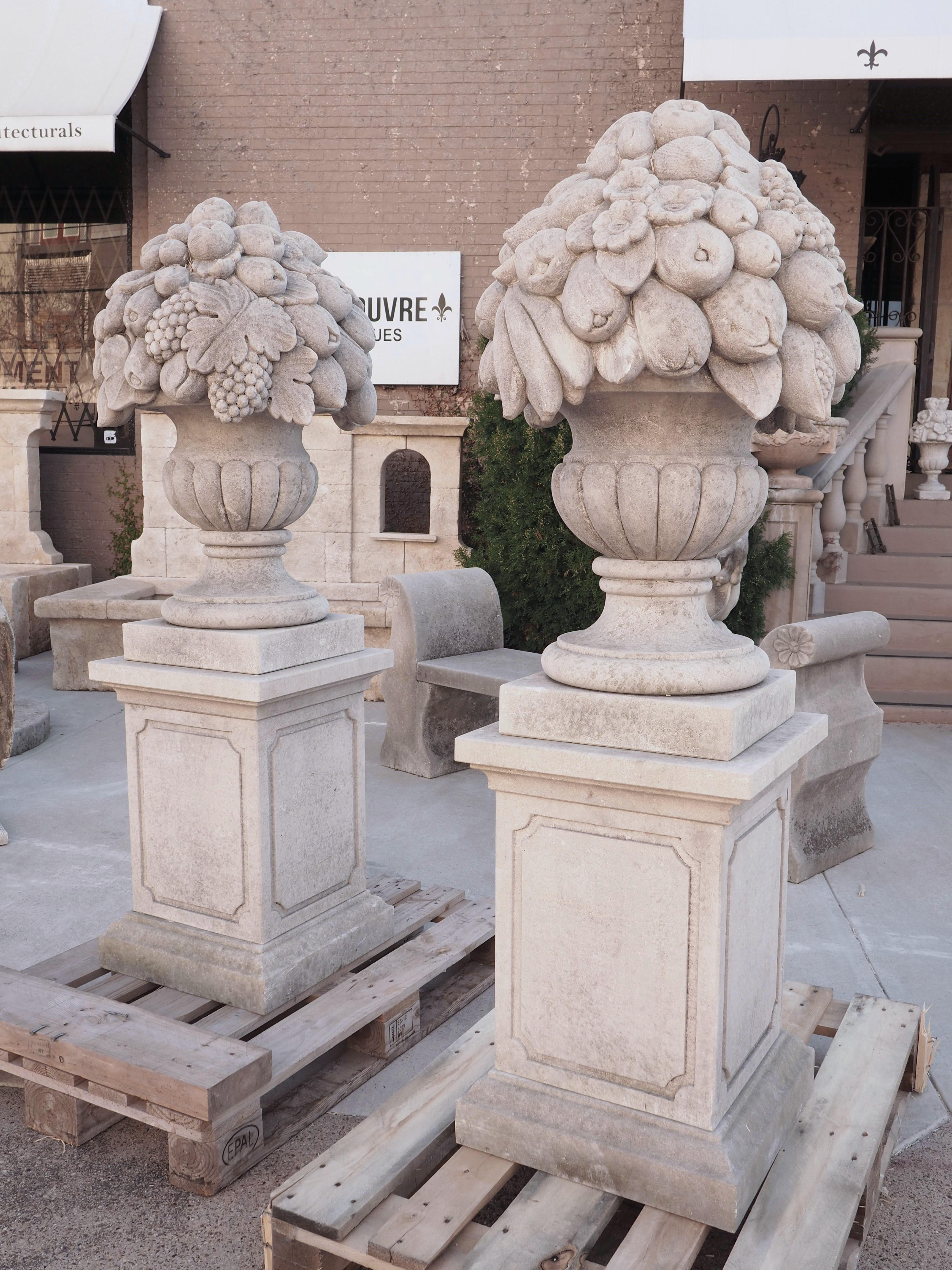 Hand-Carved Pair of Italian Limestone Urns with Fruit and Floral Bouquets on Pedestals For Sale