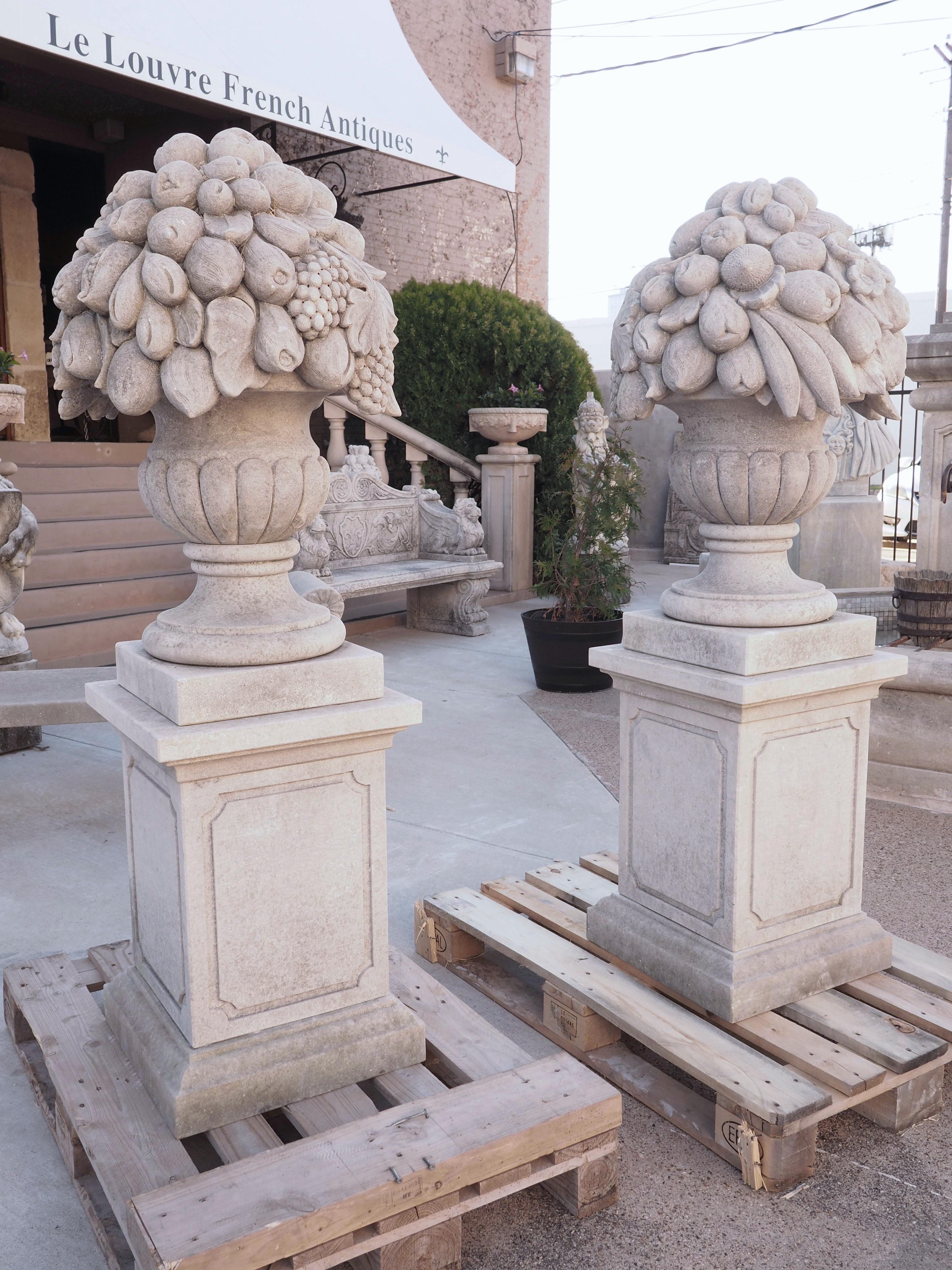 Pair of Italian Limestone Urns with Fruit and Floral Bouquets on Pedestals In Good Condition For Sale In Dallas, TX
