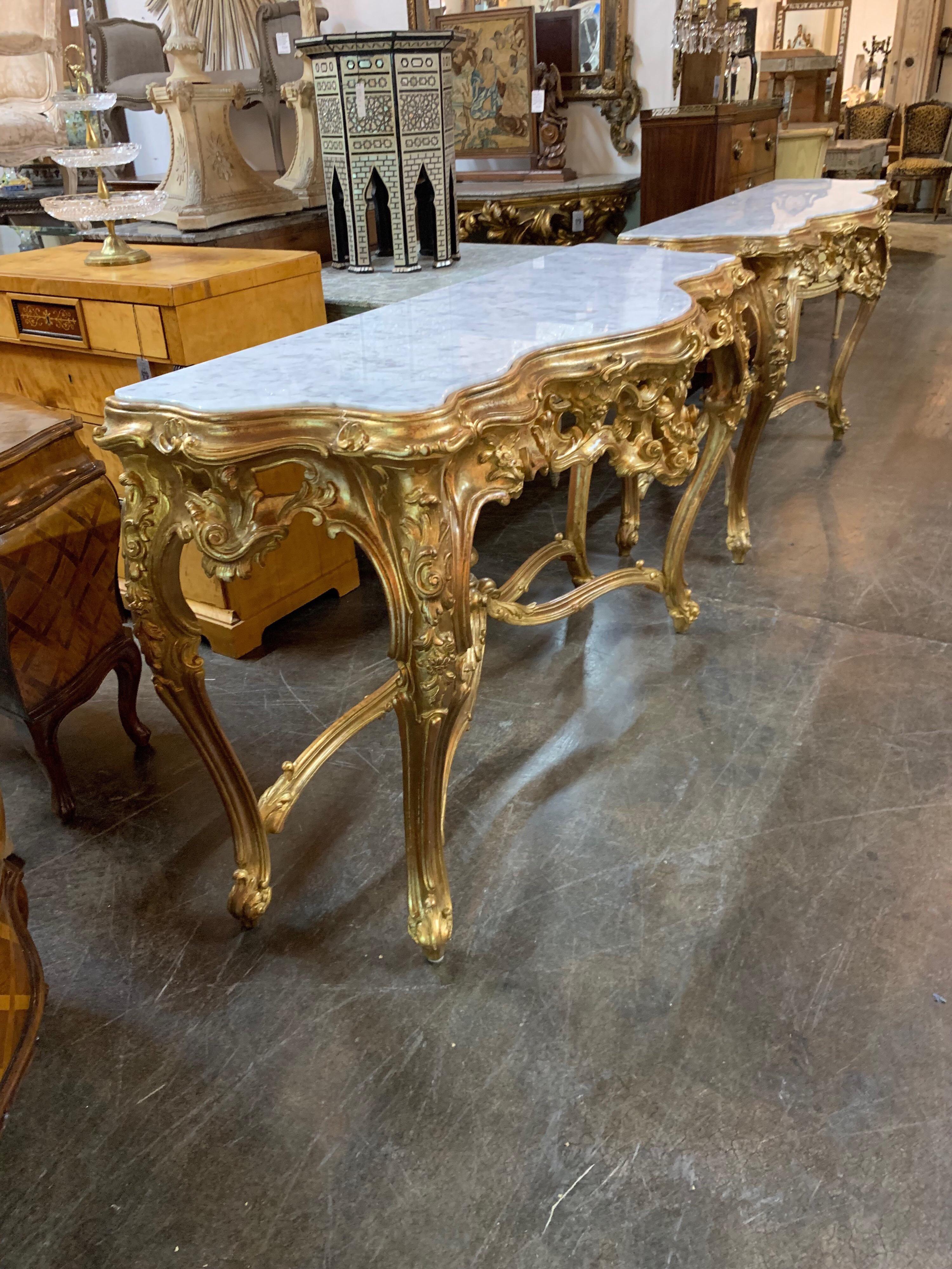 Beautiful pair of Italian Louis XV style carved giltwood consoles with Carrara marble tops.
Exceptional carving and gilding on these pieces. Very special pair for an elegant home.