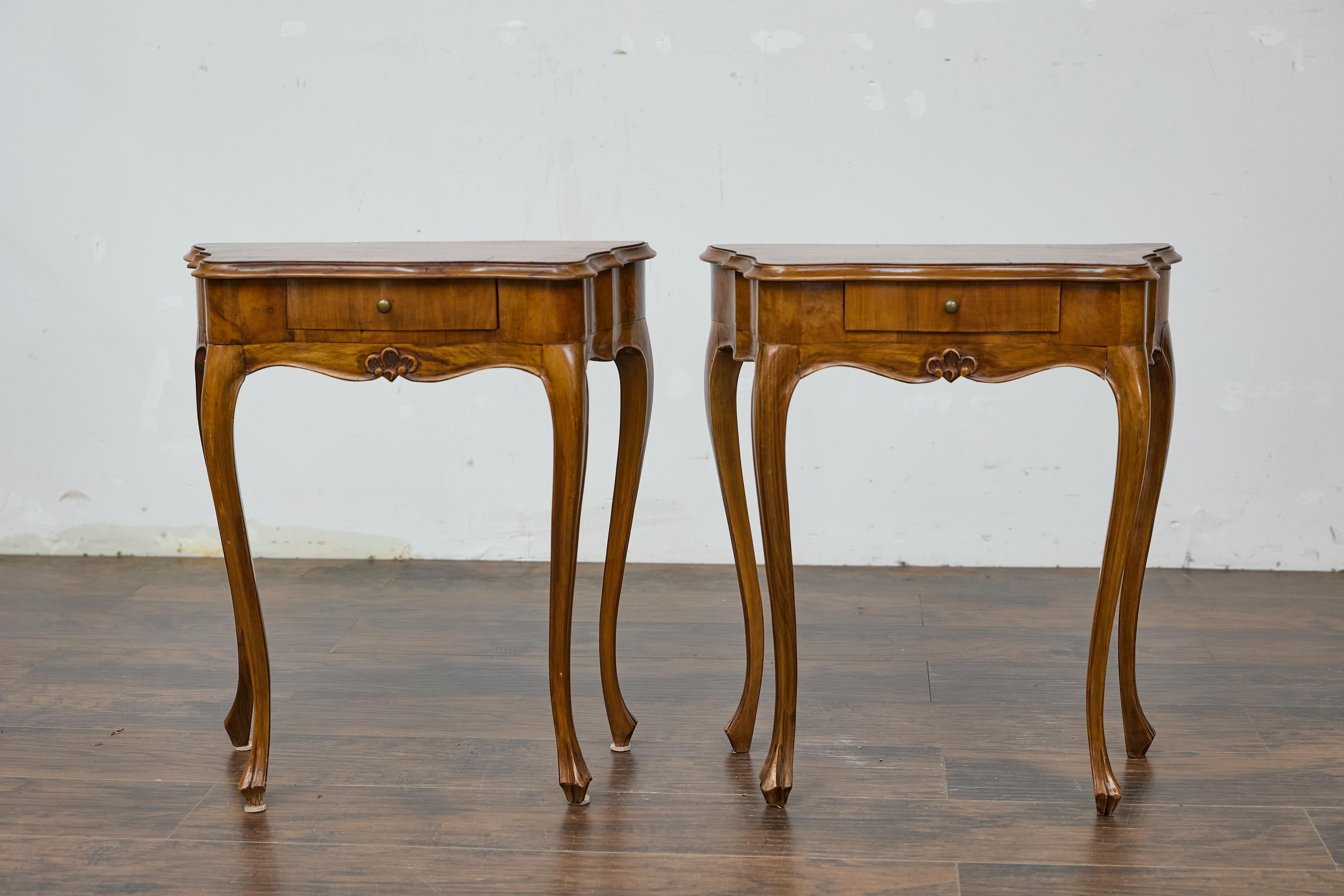 A pair of Italian Louis XV style walnut console tables with serpentine fronts, cabriole legs and single drawers. This exquisite pair of Italian Louis XV style walnut console tables charms us with its graceful serpentine fronts and elegant cabriole