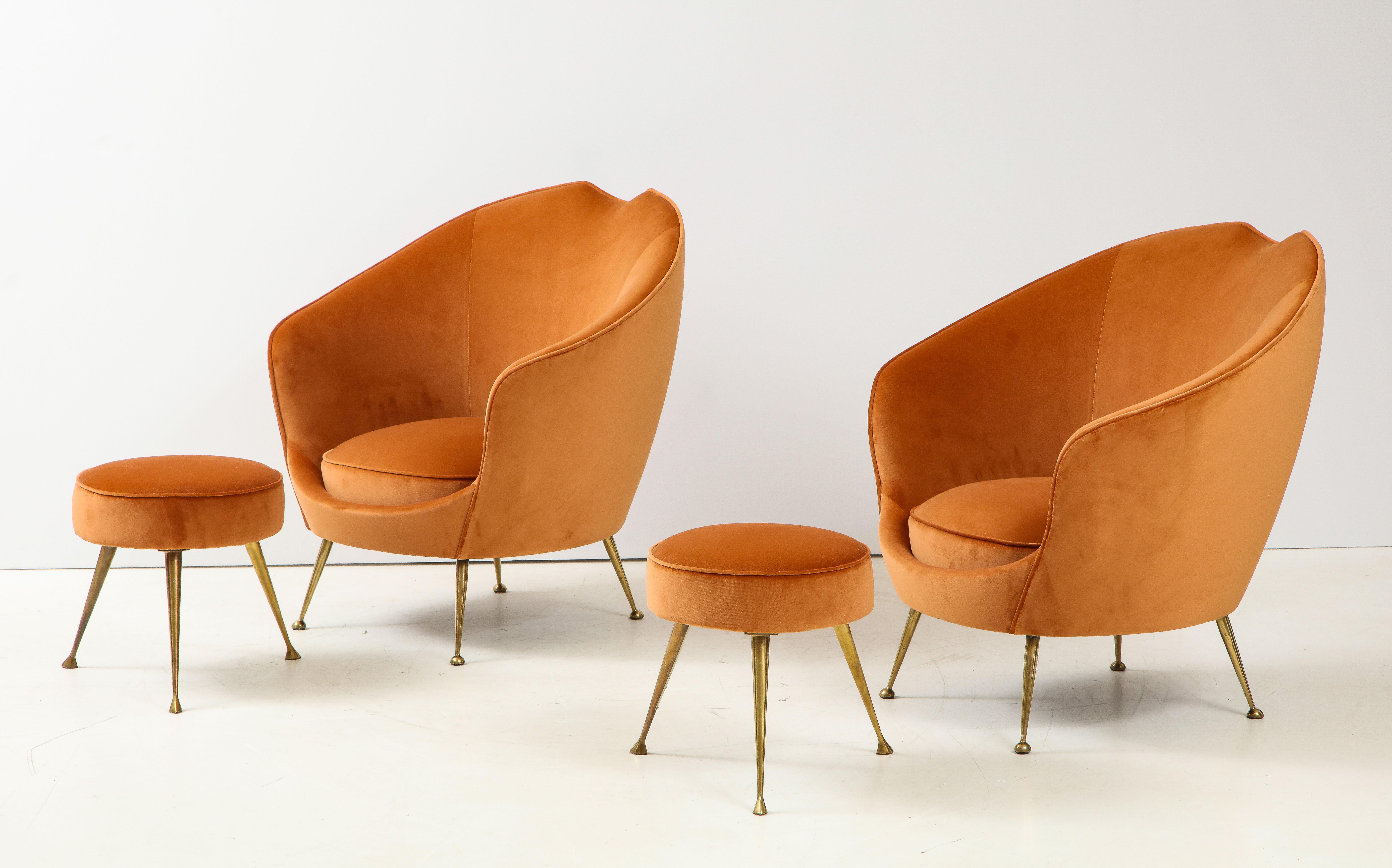 A beautiful pair of restored sculptural form Italian lounge chairs dating from the early 1950s with handcrafted wood frames. The curvaceous shape of the chair is complemented by the slope in the mid-section of the backrest. The tapered and angled