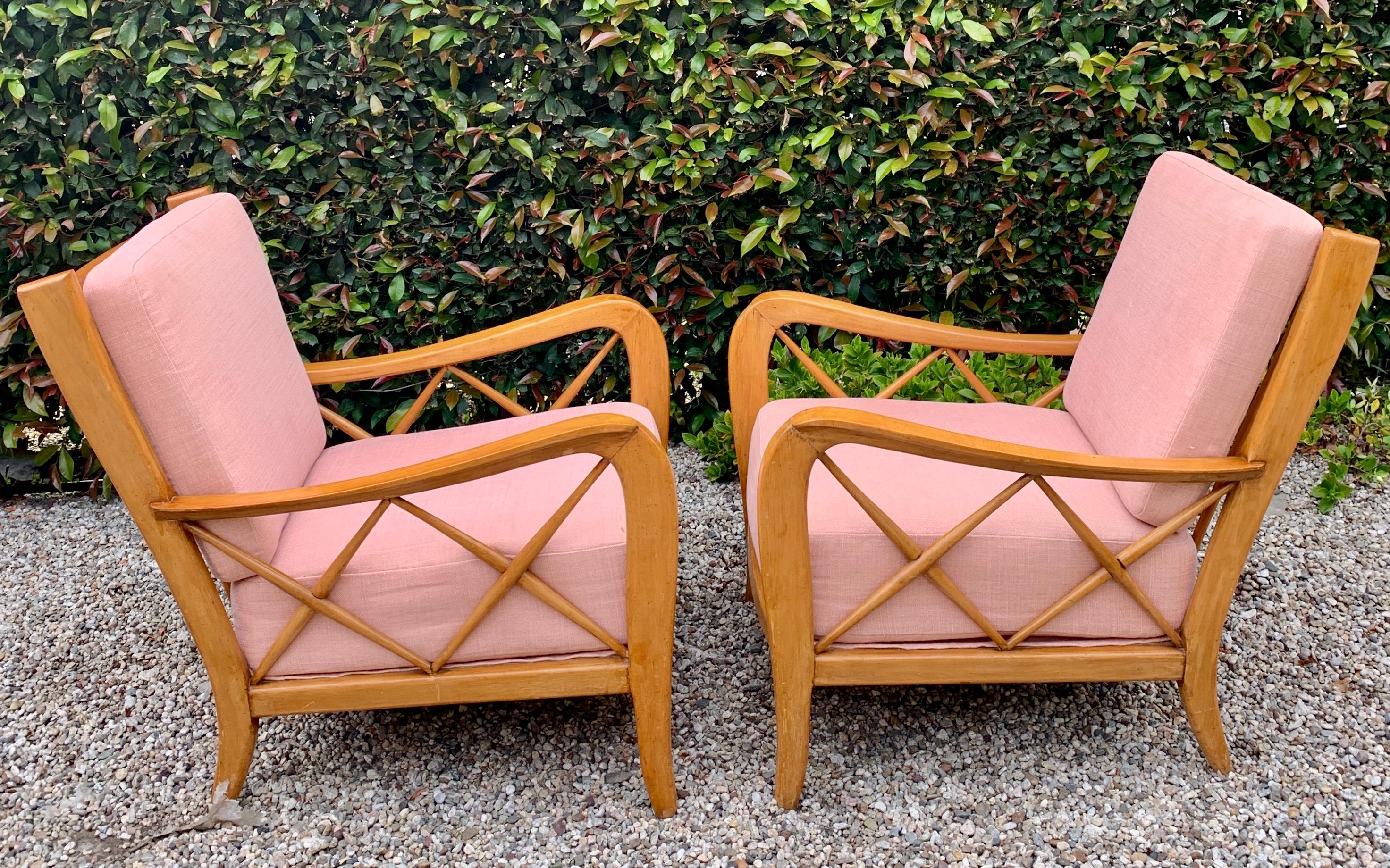A pair of Italian lounge chairs, by Paolo Buffa and upholstered in hand sewn Rose hued Pierre Frey Linen. The pair are exquisitely designed with chic, yet bold detailing - from the subtle carved wood, to the crossed arm details. The European pair