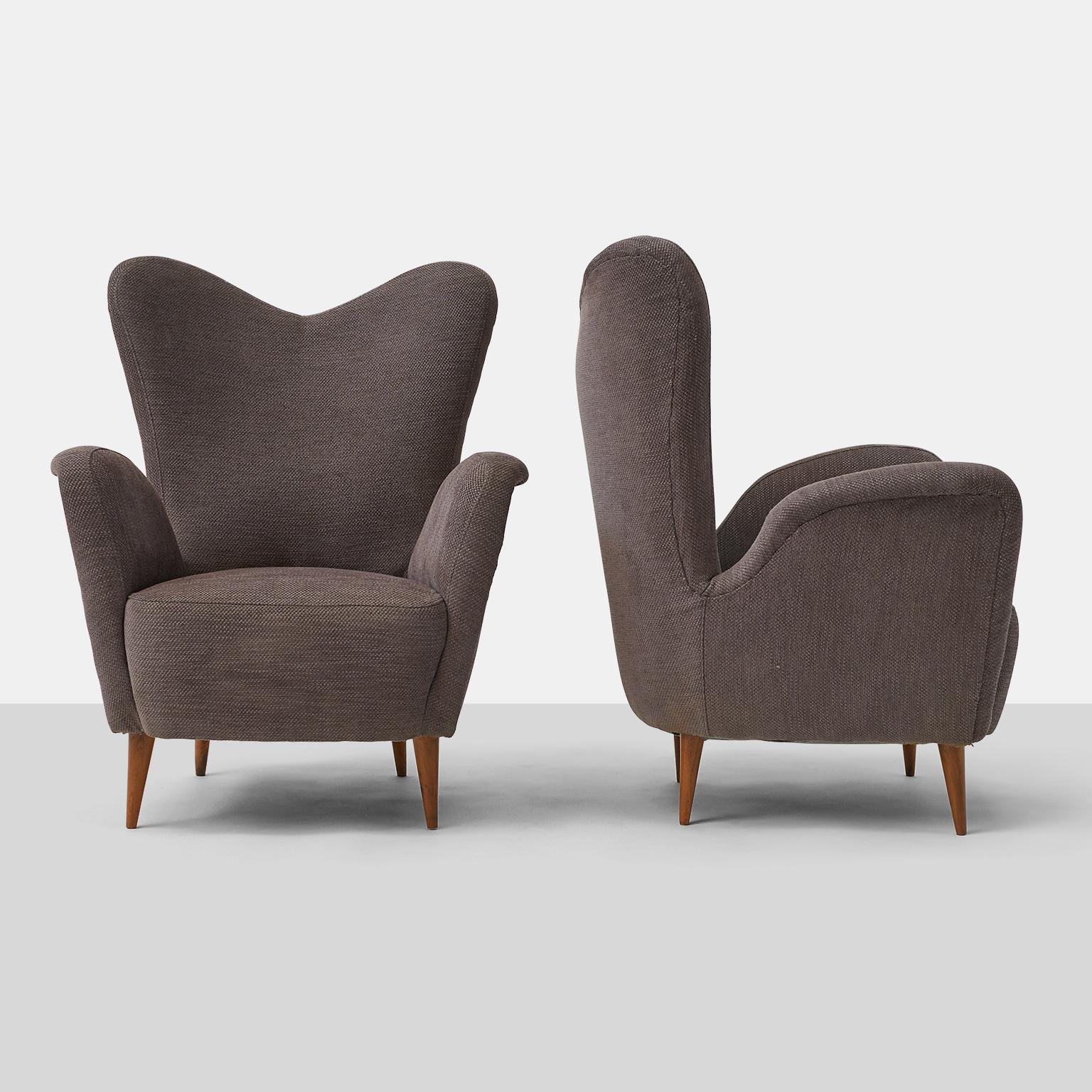 A pair of mid century Italian lounge chairs with gray upholstery and beech feet. The chairs are in very good vintage condition with some restoration to the feet.