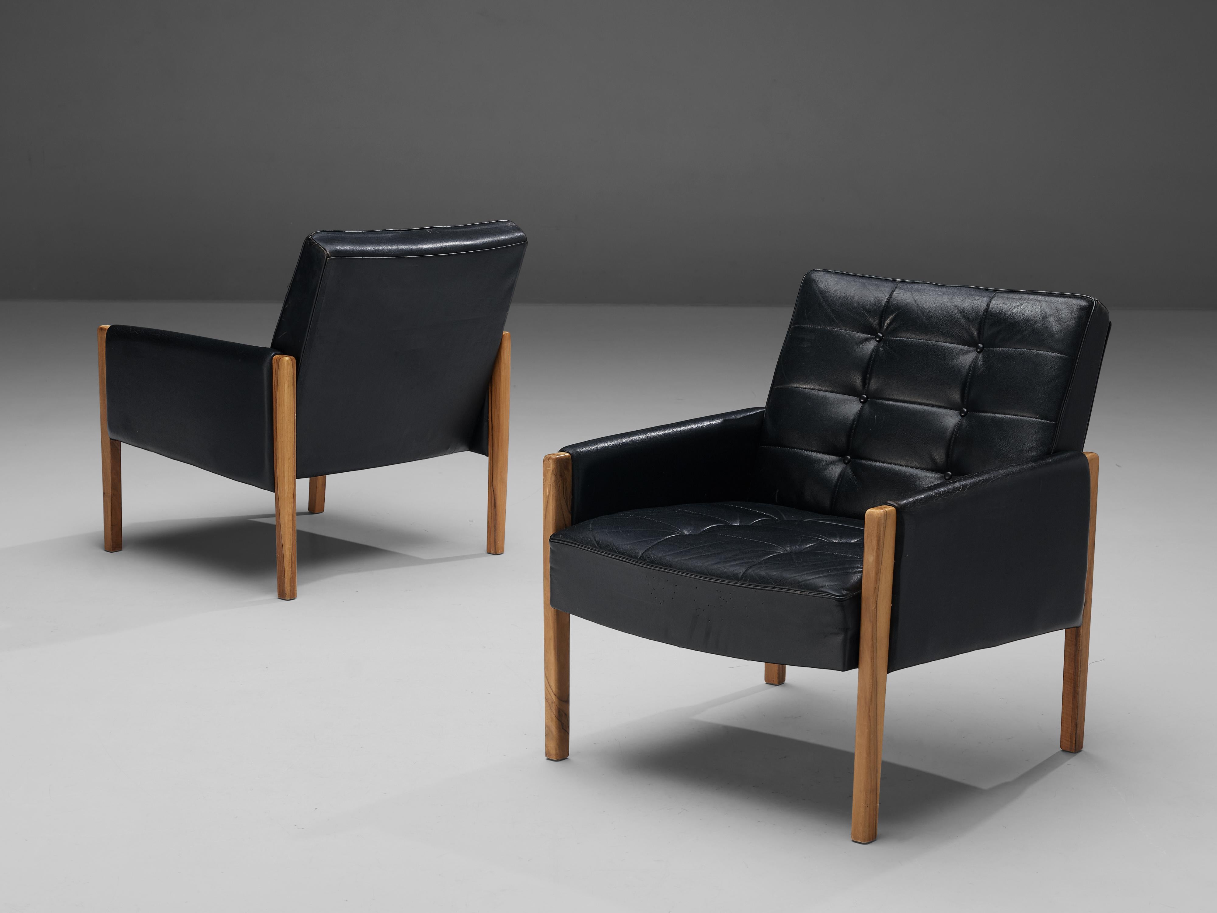 Pair of lounge chairs, leather, walnut, Italy, 1960s

Grand lounge chair in black leather and stained walnut. This chair features a solid wooden base with a tufted leather seating placed on top of the wooden frame. The armrests are also upholstered