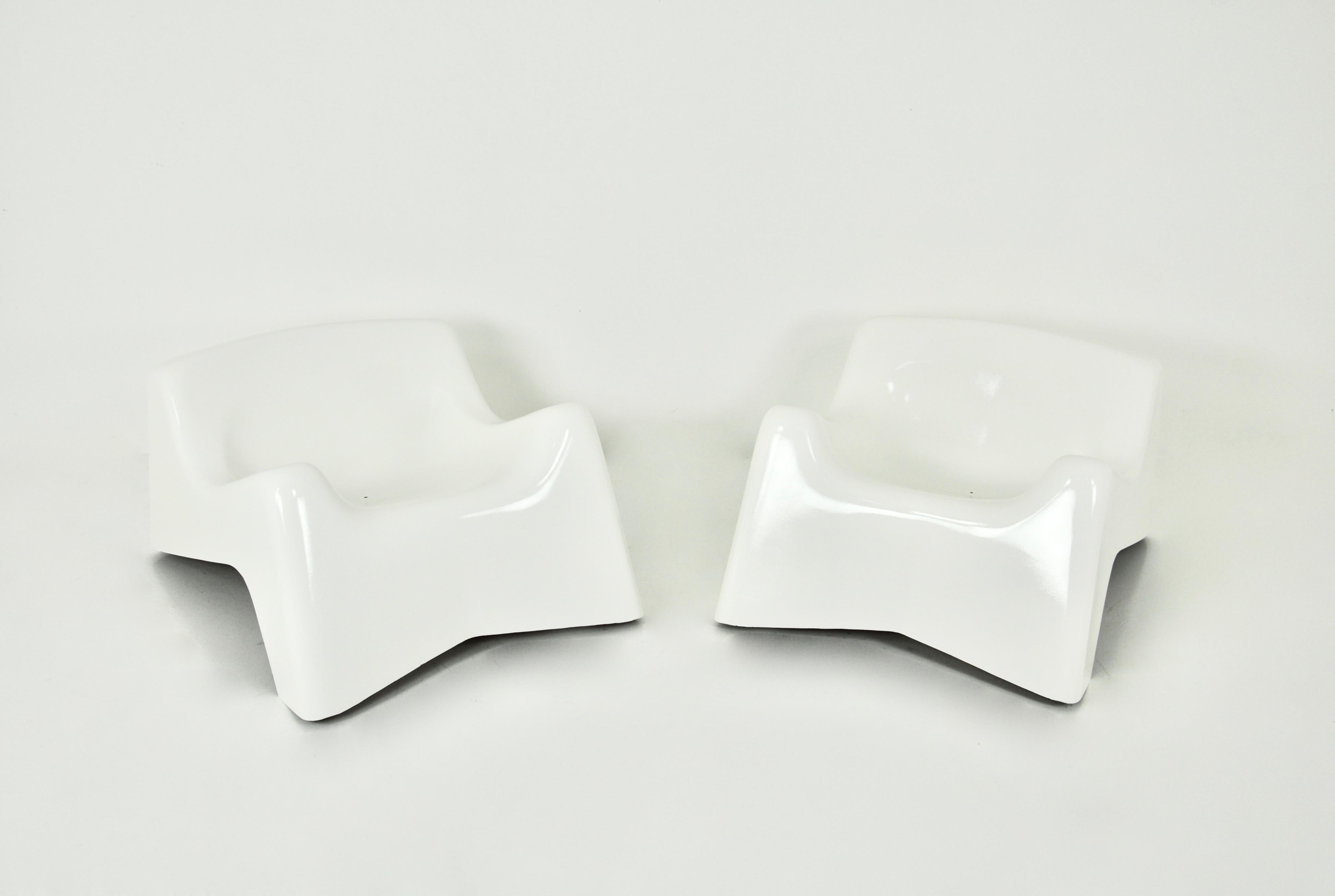 Italian white fibreglass armchairs. Wear and tear due to time and age of the chairs.