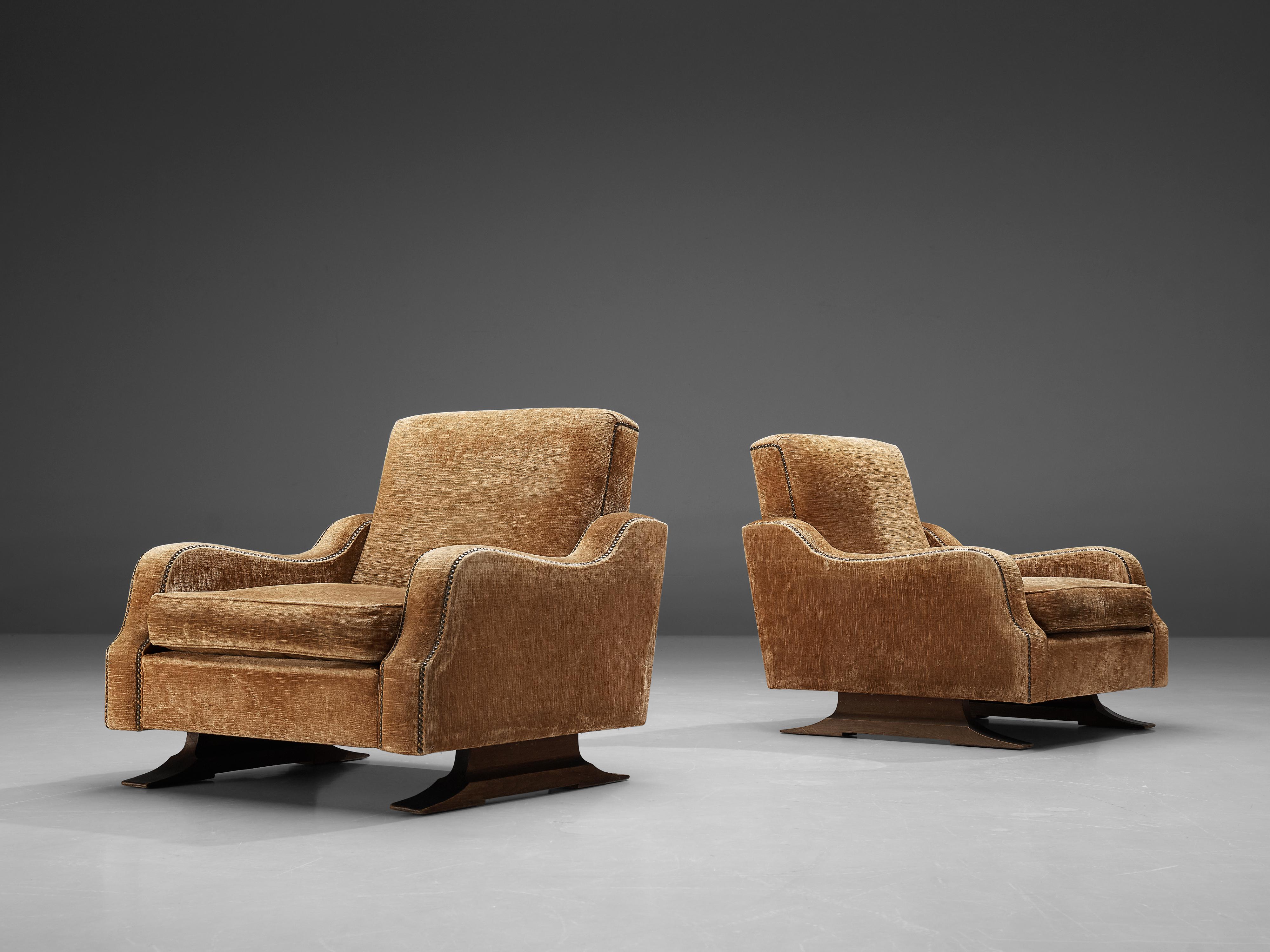 Pair of lounge chairs, darkened oak, velvet, Italy, 1950s

Gorgeous pair of lounge chairs made in Italy. The chairs have a sturdy yet elegant design. This is mainly thanks to the curved edges of the seats of the armrests. These decorated lines are