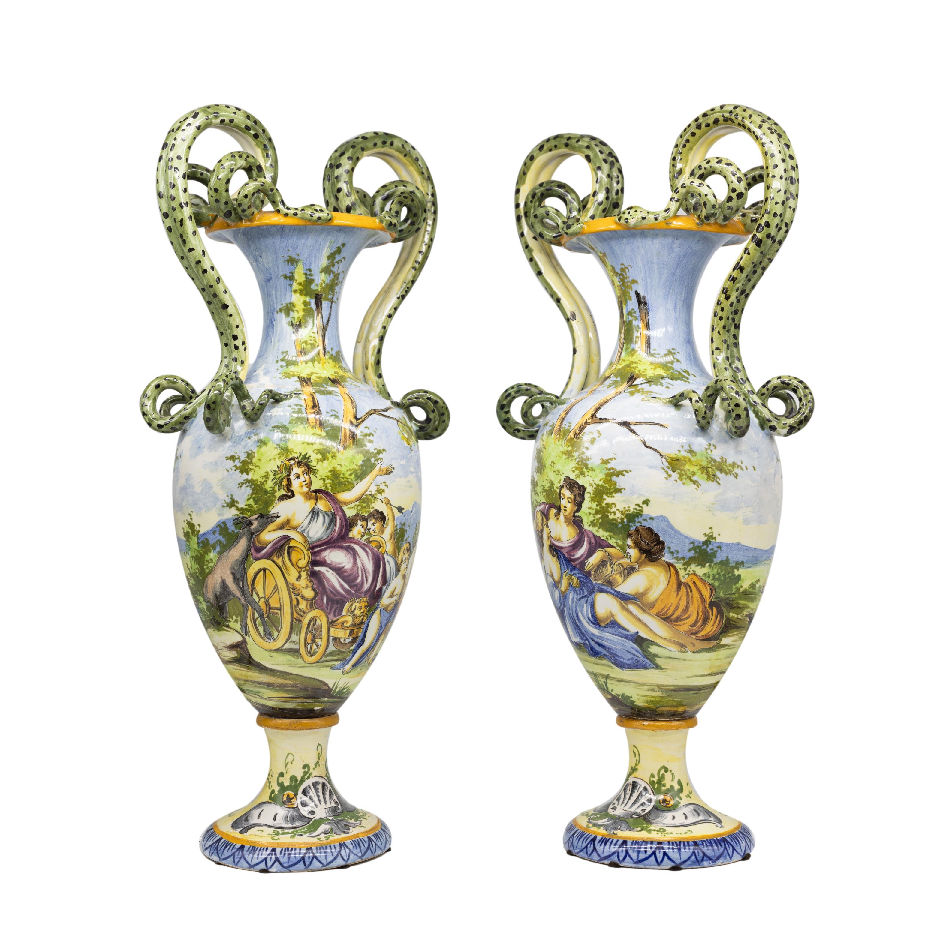 Paire de vases italiens en maïolique, de forme balustre, avec des décors polychromes de style Renassance, sur des bases piédestales, avec de grands serpents moulés et appliqués formant les poignées, le revers avec la marque de Capodimonte pour
