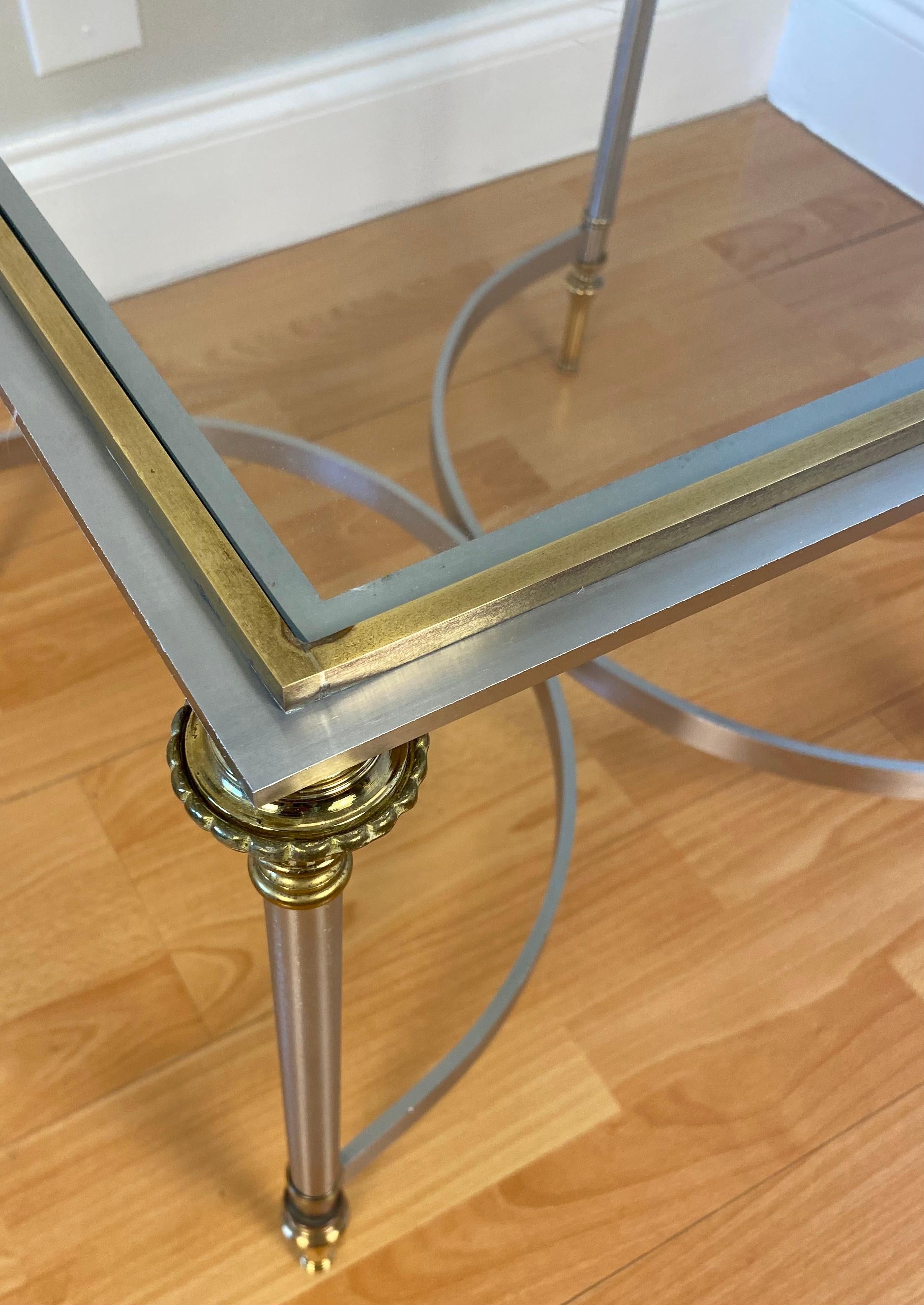 An Italian pair of Maison Jansen style brushed steel & brass end tables. 
Items feature brushed steel metal frames, brass accents, intentional and a beautiful antiqued finish. 

Very good quality vintage pair, interesting style, form and fine