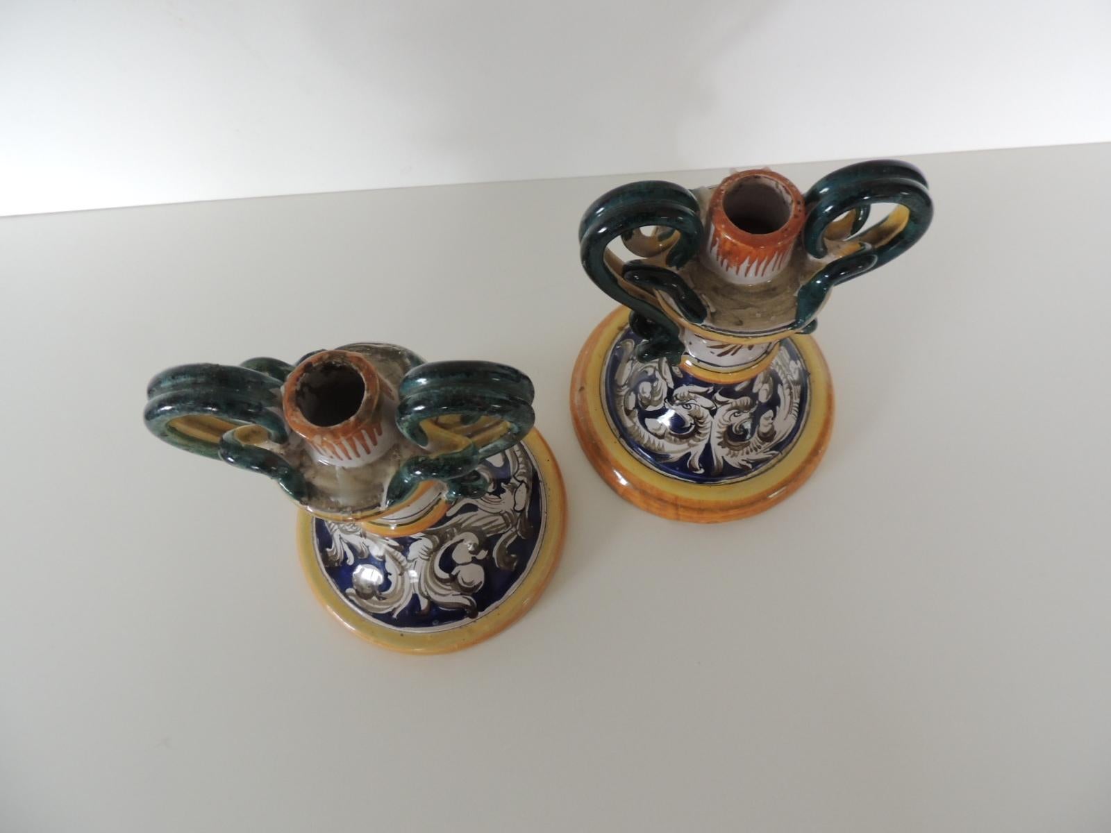 Pair of Italian Majolica hand painted candleholders.
Round base candleholders depicting dolphins in shades of white, yellow, green, royal blue and white.
Stamped: Made in Italy.
Size: 6.3/4