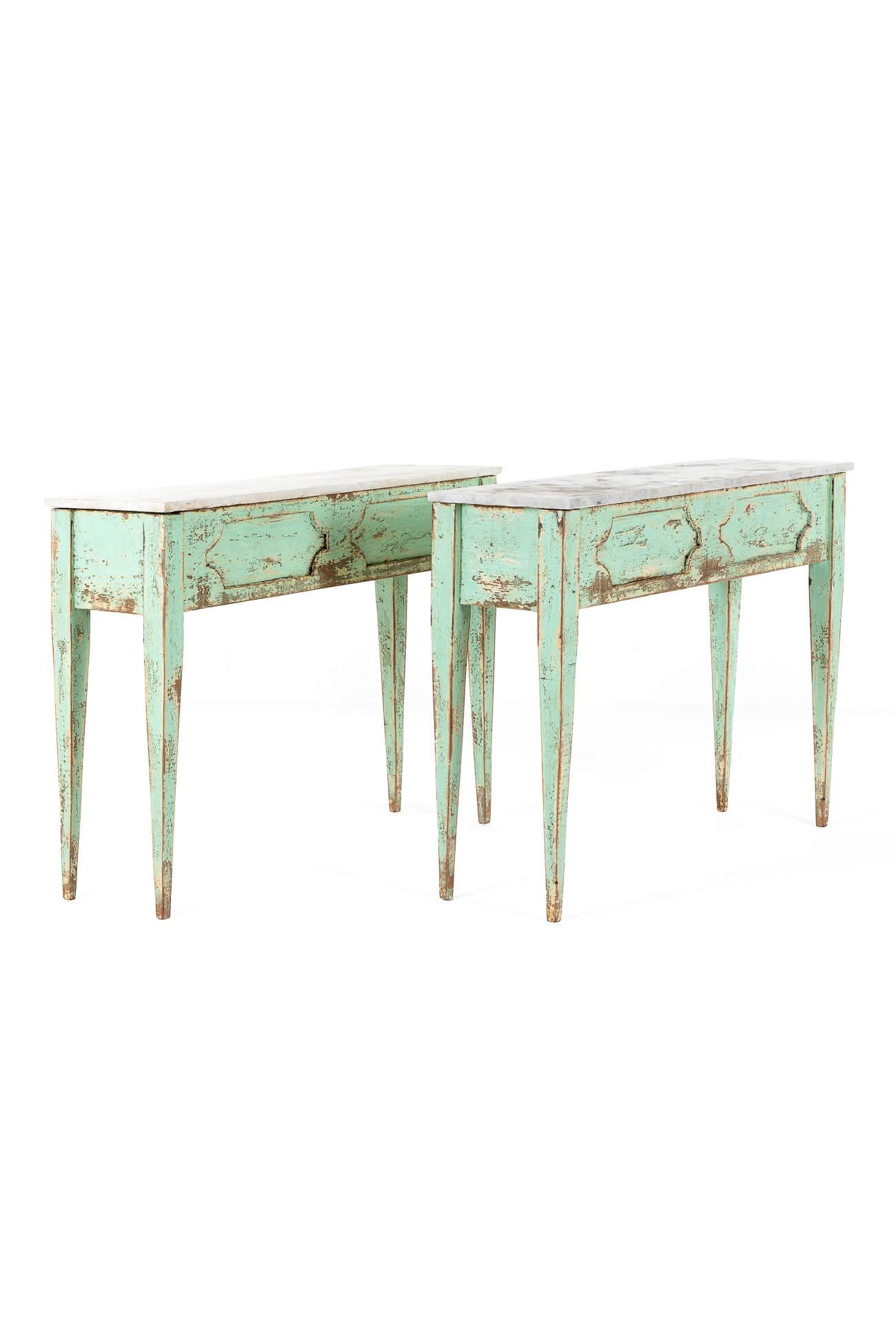 A wonderful pair of console tables with aged mottled white marble tops.

The bases in a chipped mint green finish both have a molded freize to the front and are raised on carved tapered legs.

Price is for the pair.

Italian, 20th