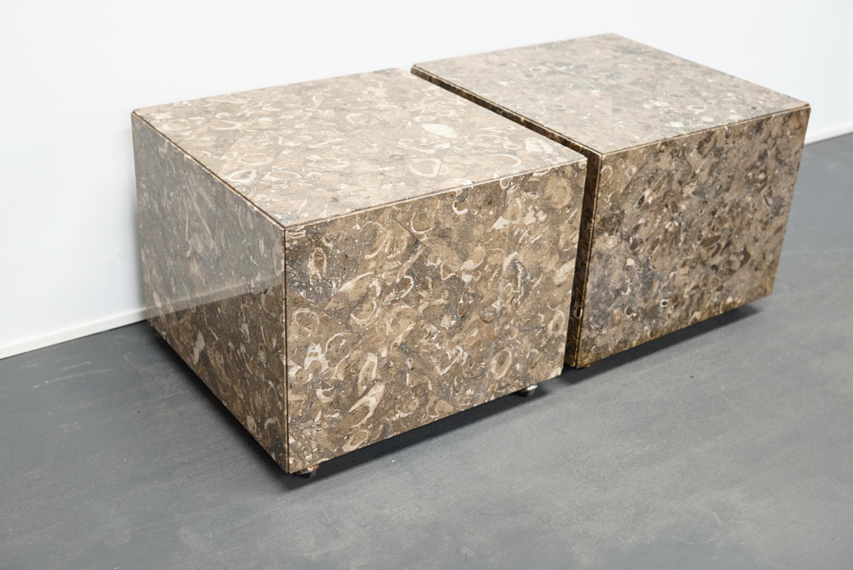 This pair of decorative herringbone pattern marble or fossil tiled side tables with concealed casters were designed and made around the 1970s in Italy. The marble cubes have some small chips around the edges.