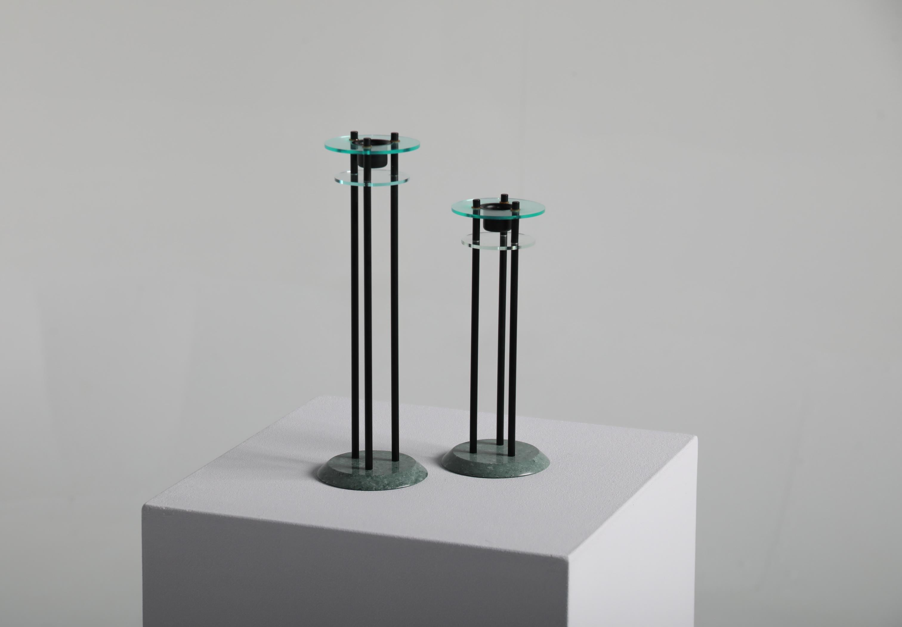 Una coppia scultorea di candelieri italiani degli anni '80, che riflette l'estetica audace ed espressiva associata al movimento Memphis. Ogni pezzo combina materiali e forme contrastanti, dando vita a un oggetto decorativo di grande impatto che