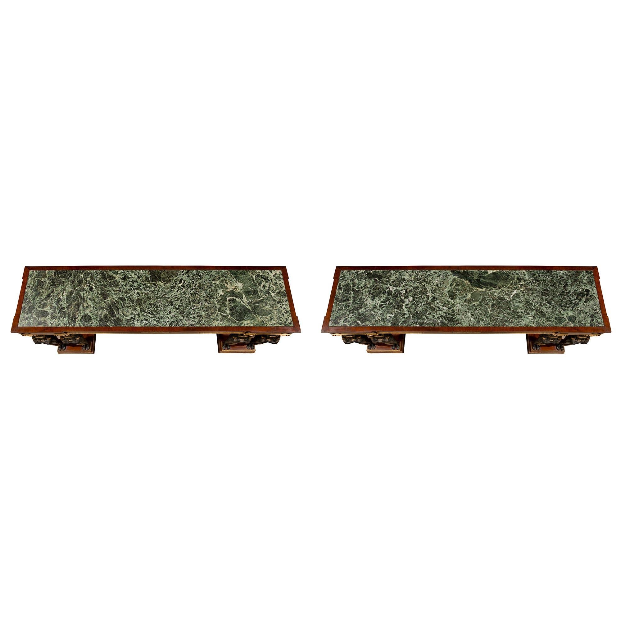 A sensational pair of Italian mid 19th century Empire st. freestanding flamed mahogany consoles from Naples, Italy. The consoles are raised by double mottled rectangular bases with brass edges. Each flamed mahogany console is supported by patinated