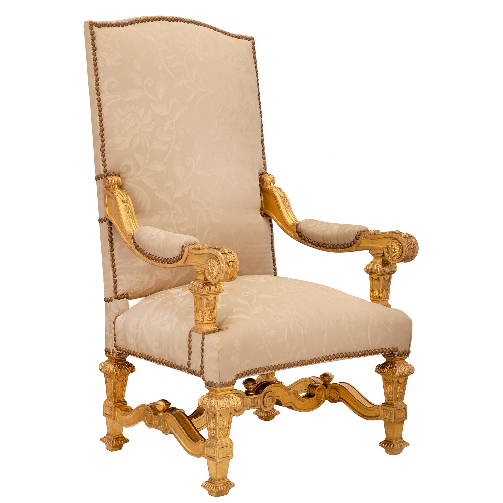 A most impressive pair of Italian mid-19th century Louis XIV st. giltwood armchairs. Each armchair is raised by handsome square tapered legs with fine reeded block feet and rich foliate designs. Each leg is connected by an elegant scrolled