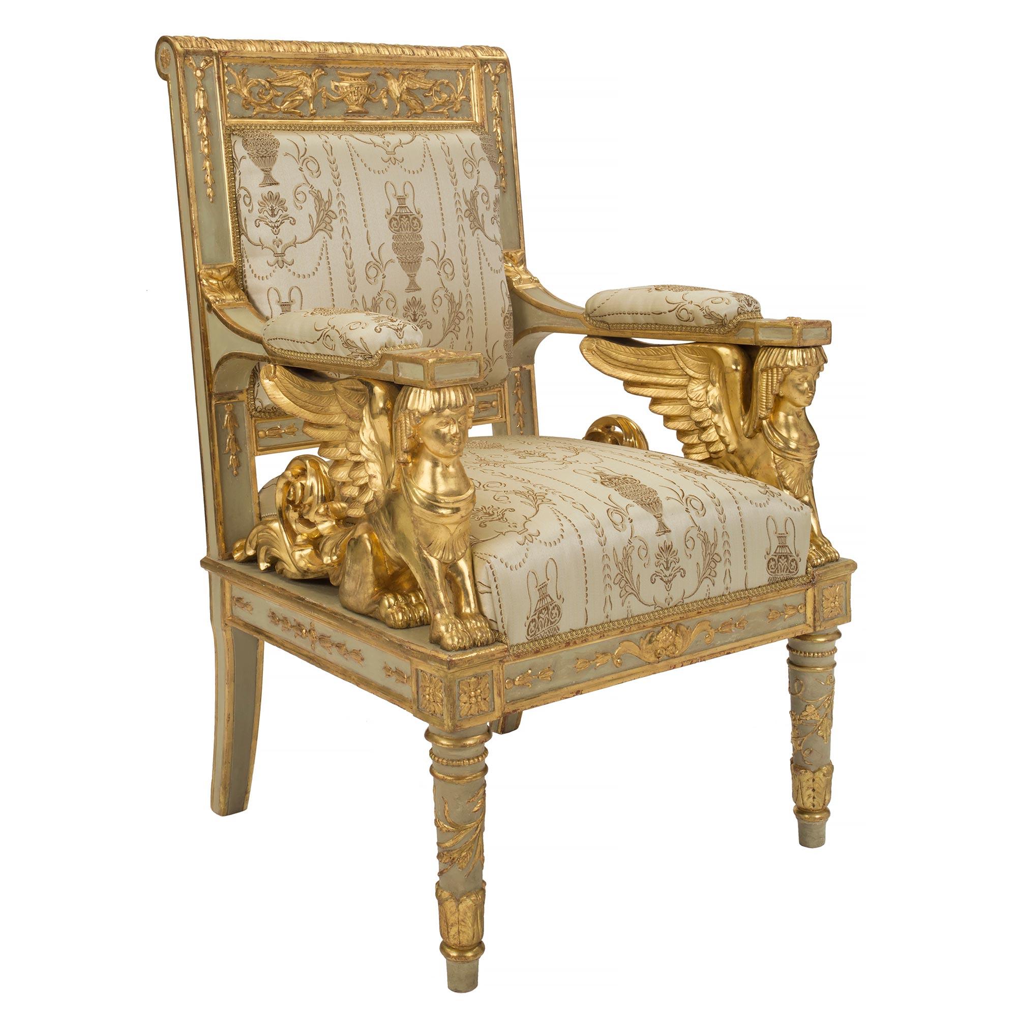 An exquisite pair of Italian mid 19th century Neo-Classical st. armchairs. The light green patinated frame is stunningly decorated with giltwood designs throughout and three matching upholstered pillows. Raised by front tapered topie shaped legs