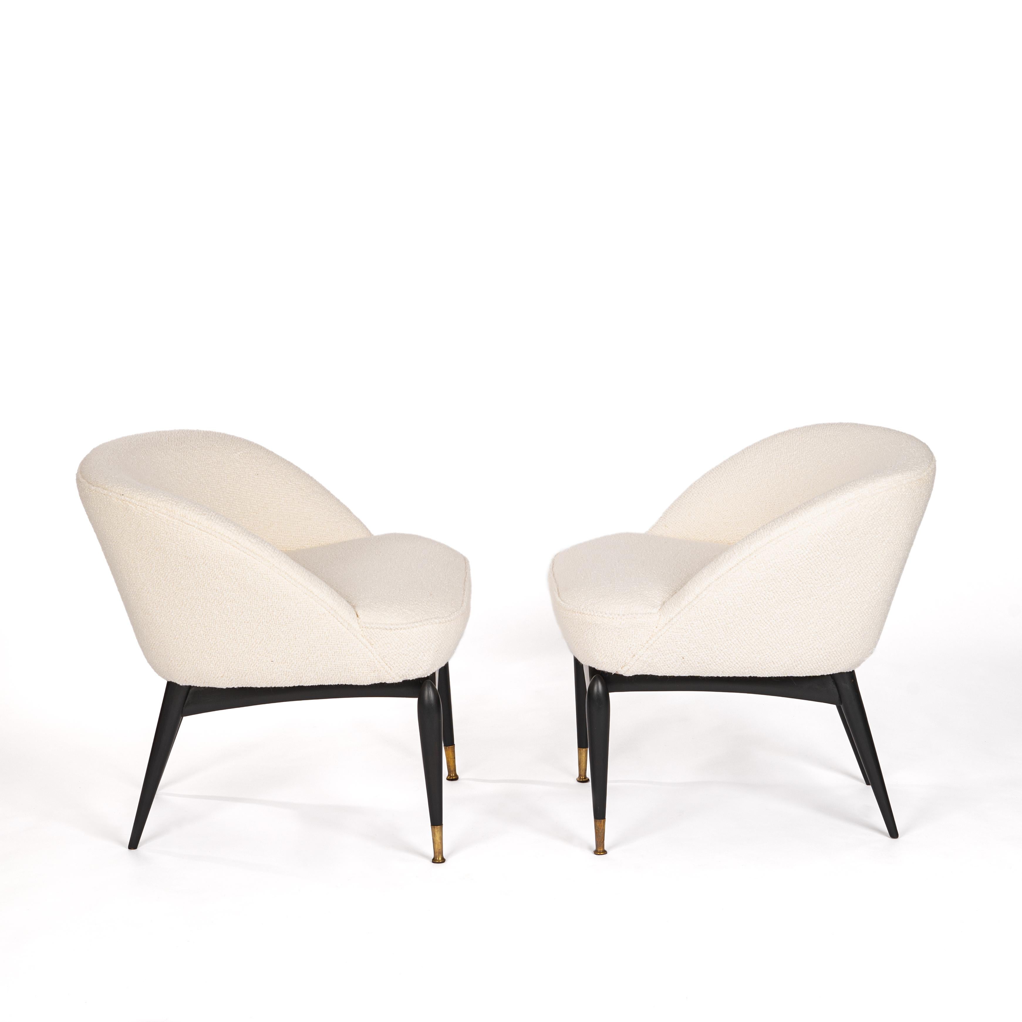 Pair of comfortable, exceptional Italian mid-century armchairs from the 1950s. 
All elements are rounded - the seat shell is almost floating on the substructure. 
Front legs free-standing, light-footed design. 
Completely reupholstered and covered